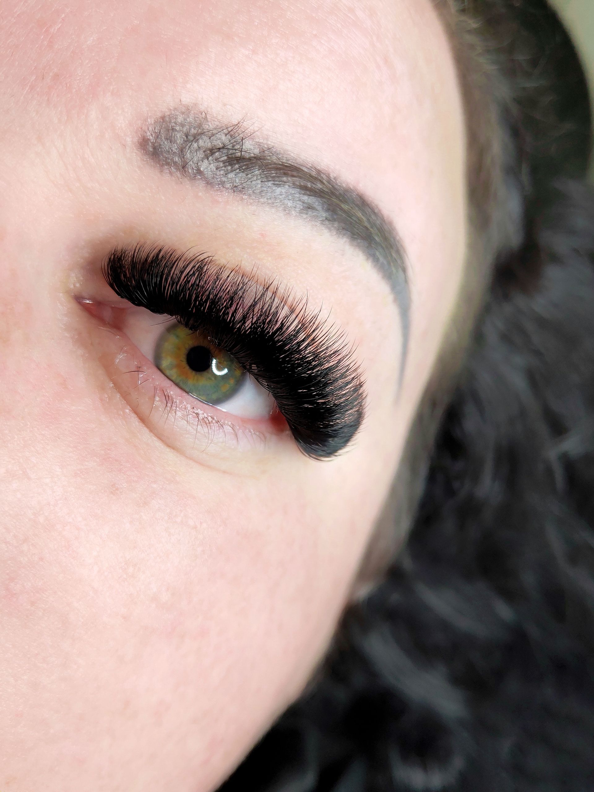 A close up of a woman 's eye with long black eyelashes.