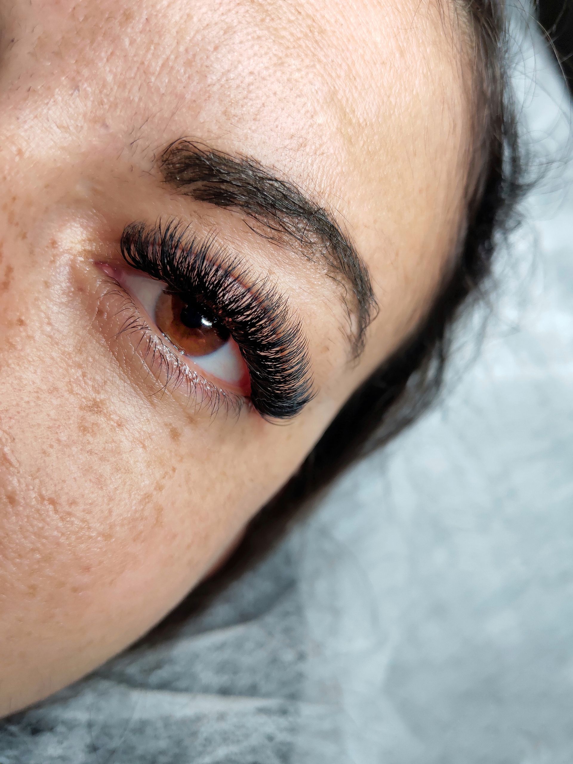 A close up of a woman 's eye with long eyelashes.