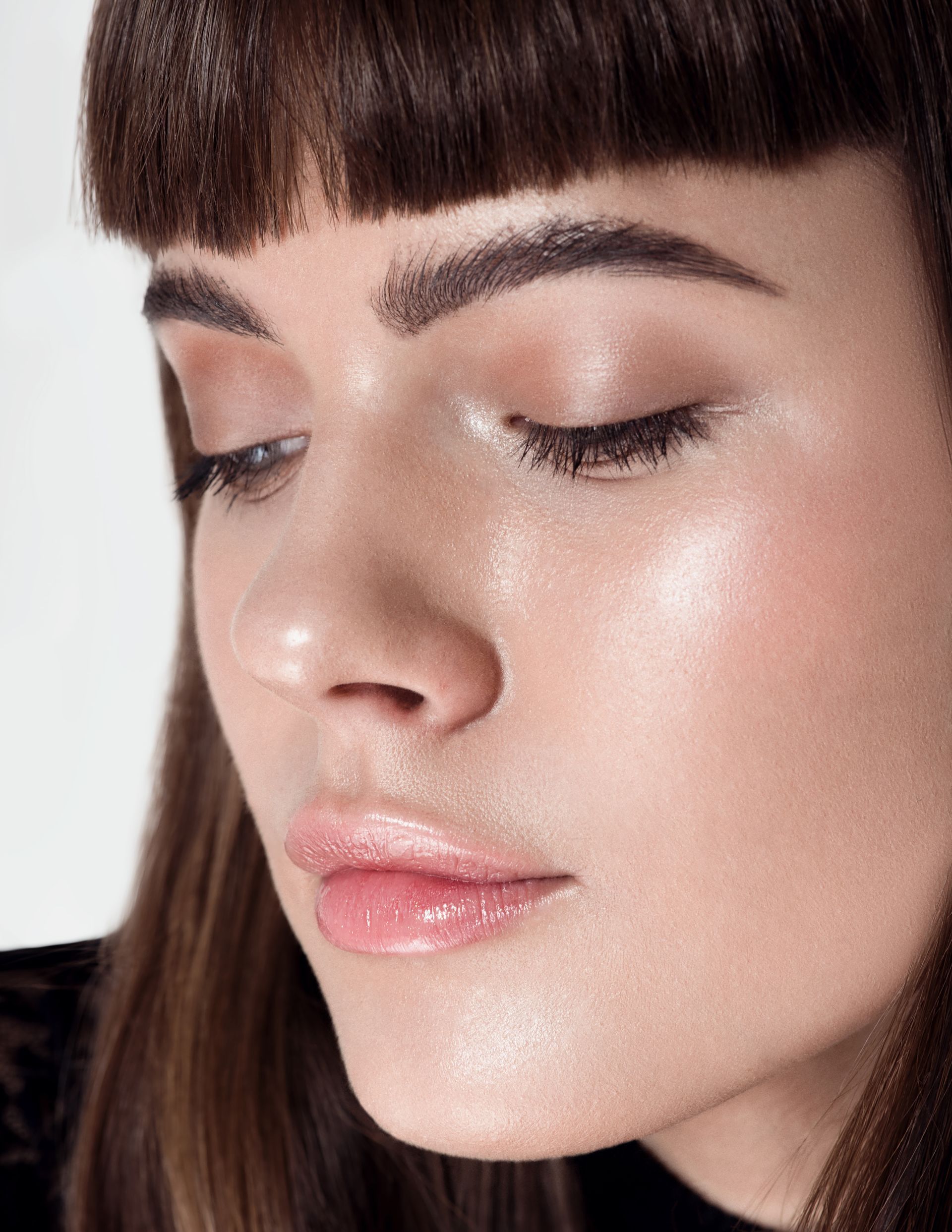 A close up of a woman 's face with her eyes closed.