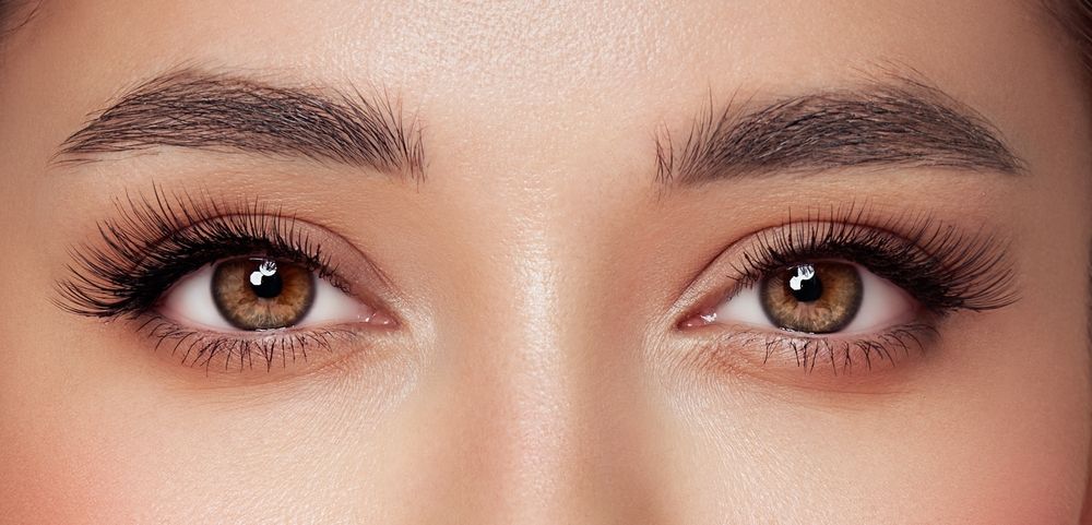 A close up of a woman 's eyes with long eyelashes.