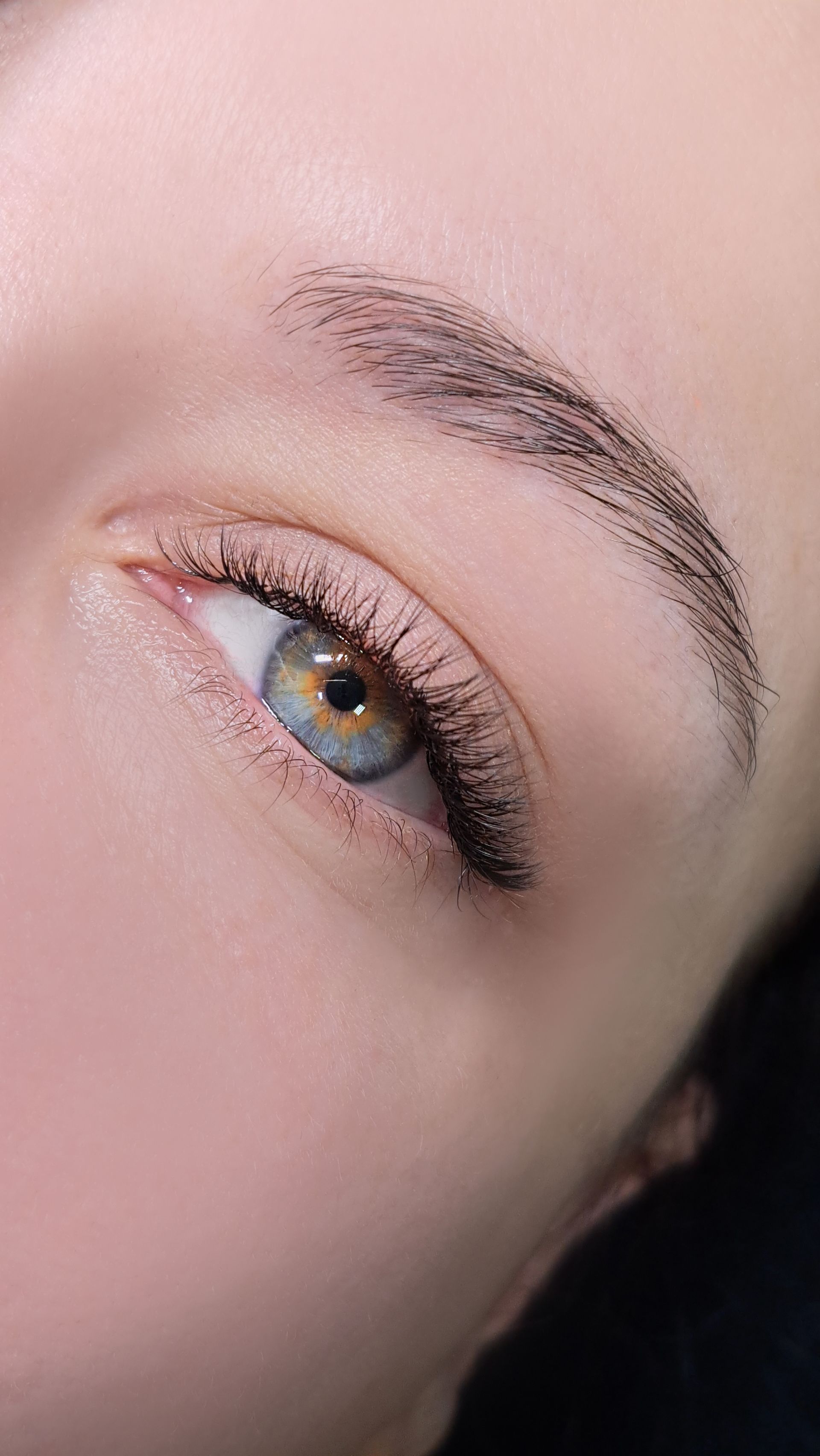 A close up of a woman 's eye with long eyelashes.