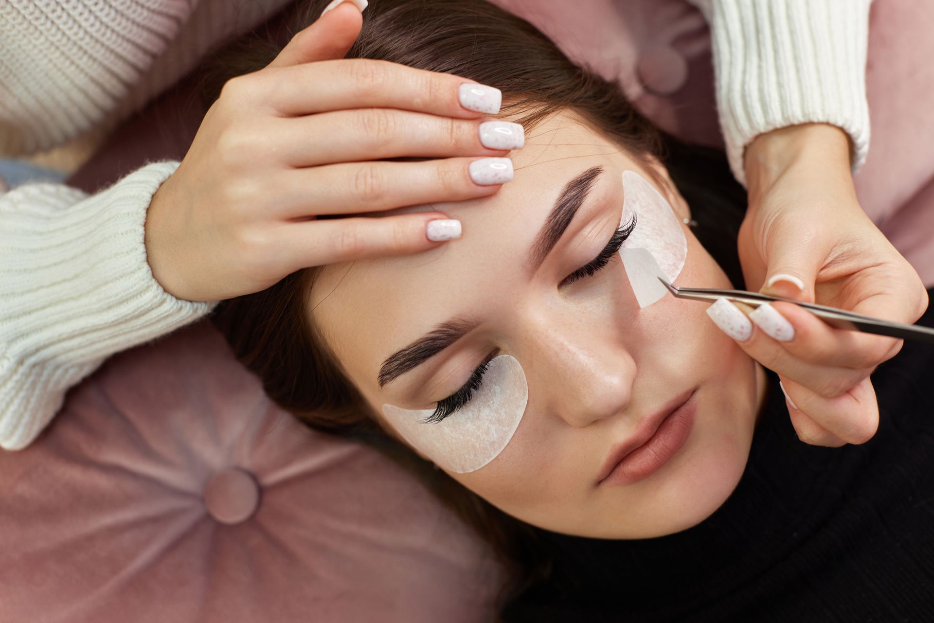 A woman is getting her eyelashes done at a beauty salon.