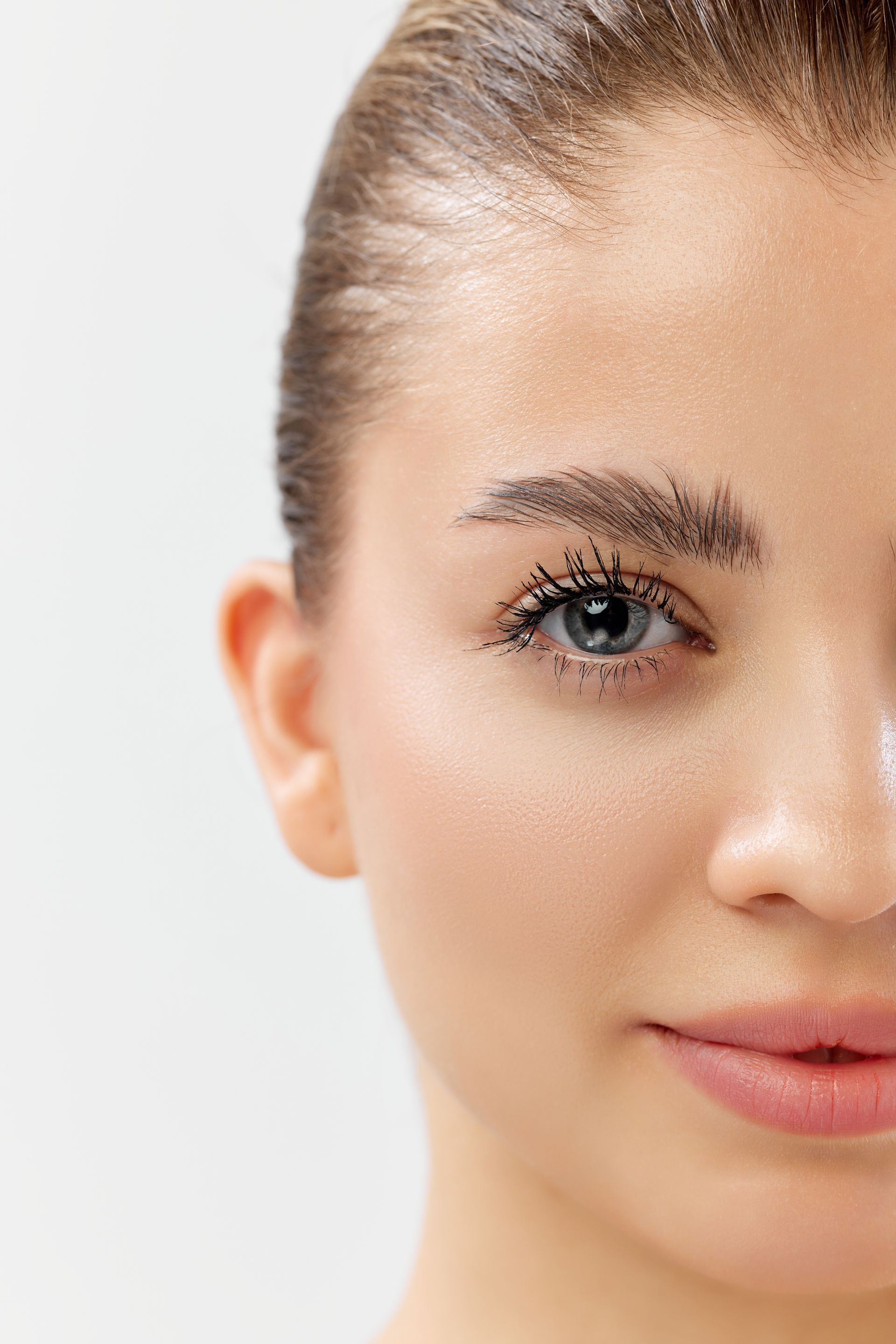 A close up of a woman 's face with mascara on her eyelashes.