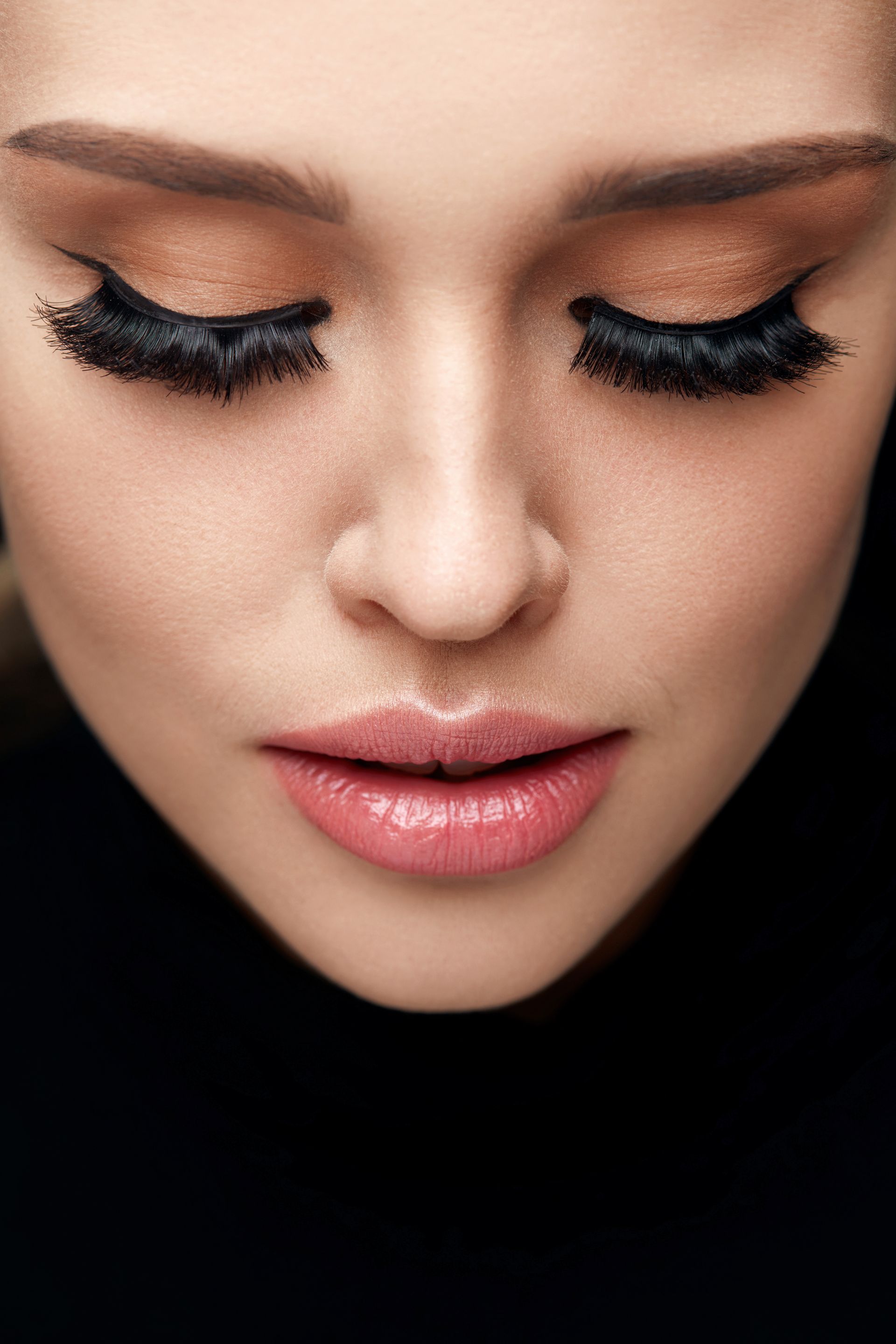 A close up of a woman 's face with her eyes closed.