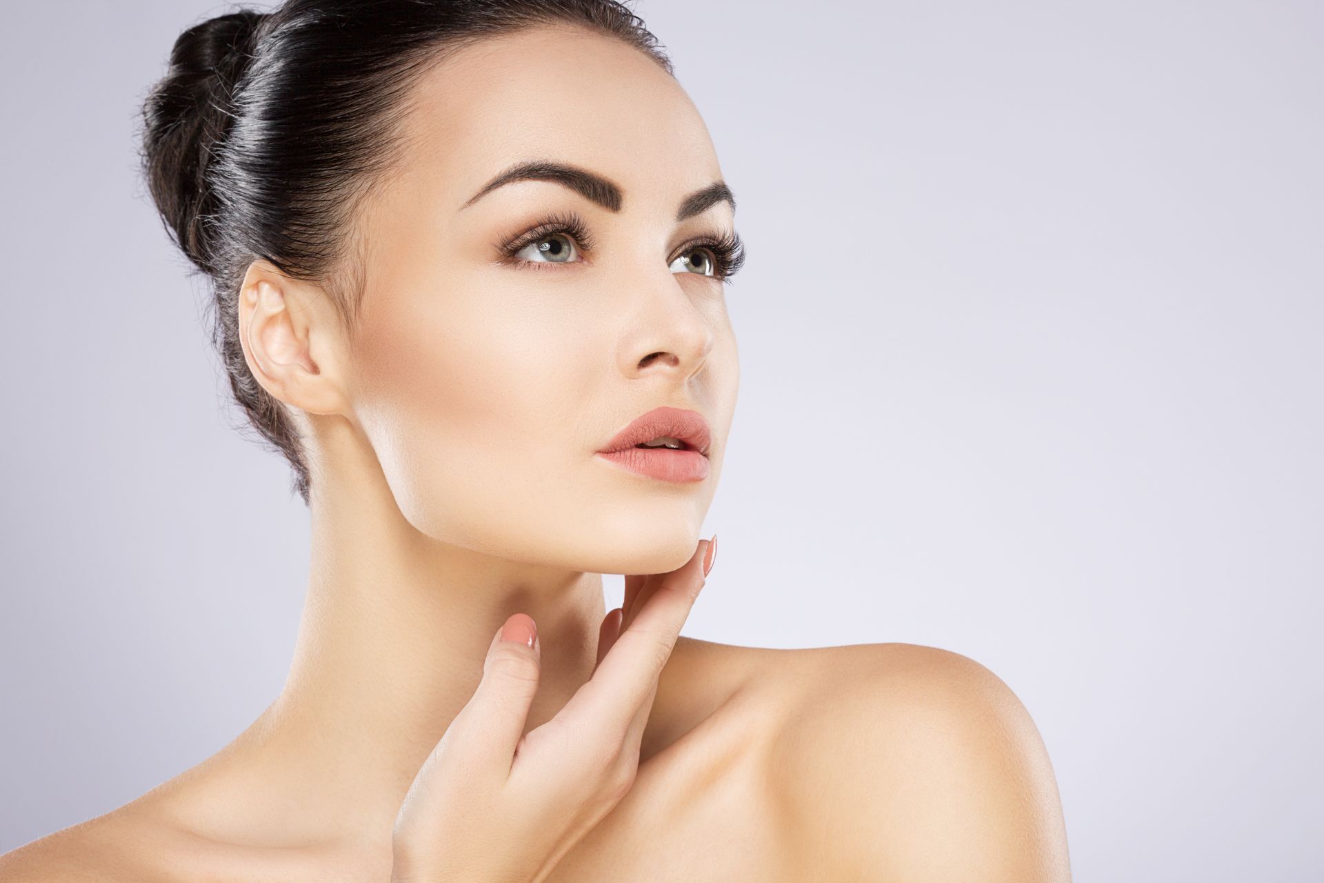 A close up of a woman 's face with her hand on her chin.