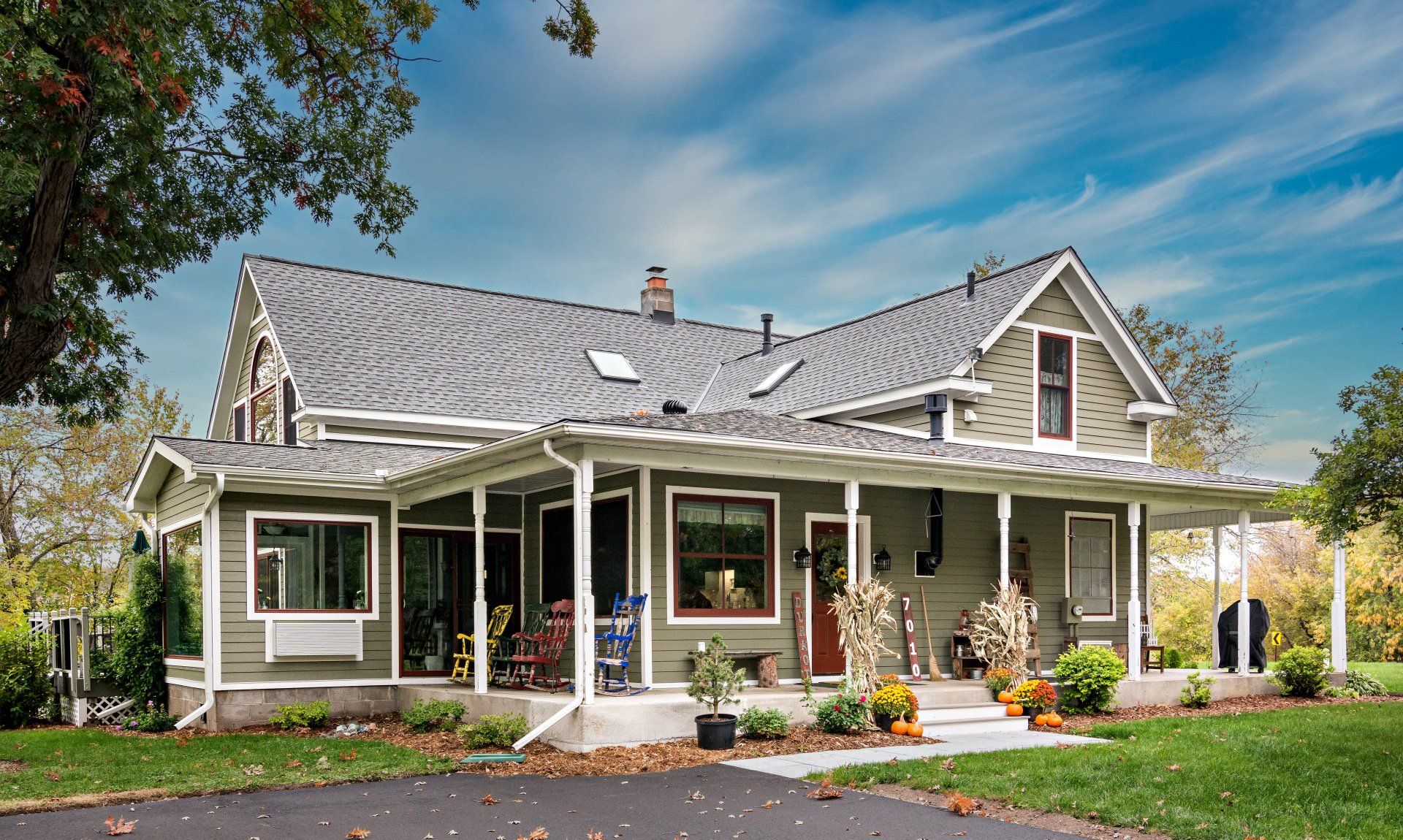 A large house with a large porch and a gray roof