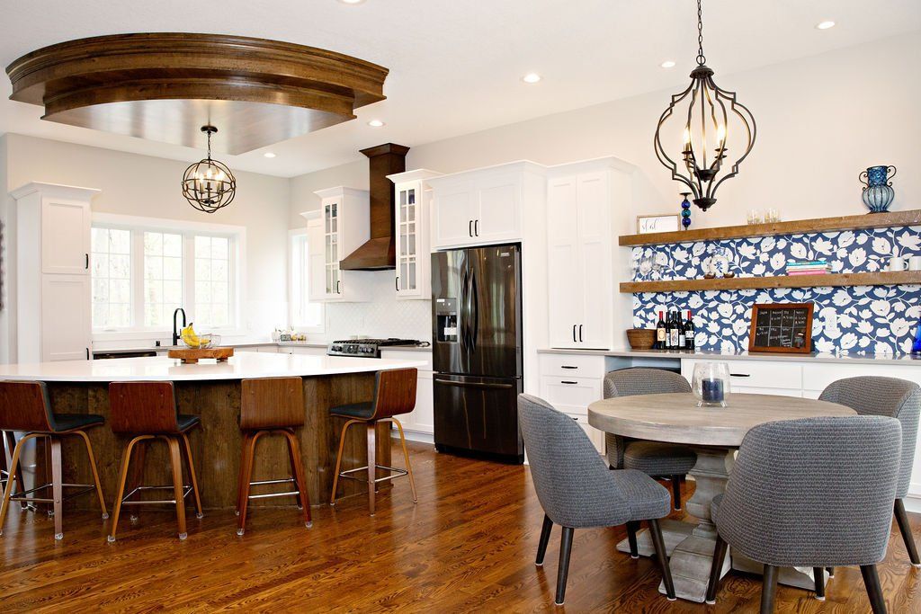 A kitchen with a table and chairs and a refrigerator.