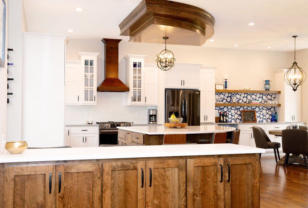 A kitchen with wooden cabinets , white cabinets , stainless steel appliances and a large island.