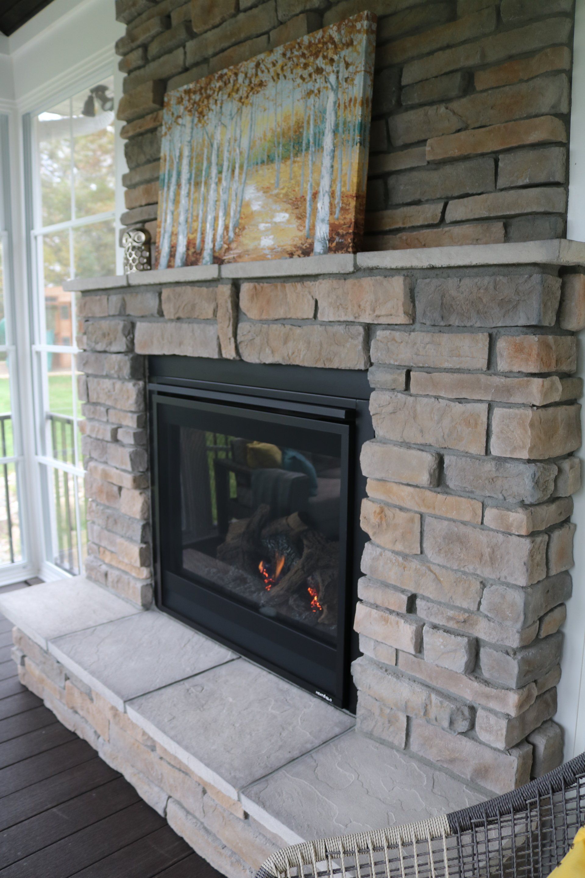 A brick fireplace with a painting above it