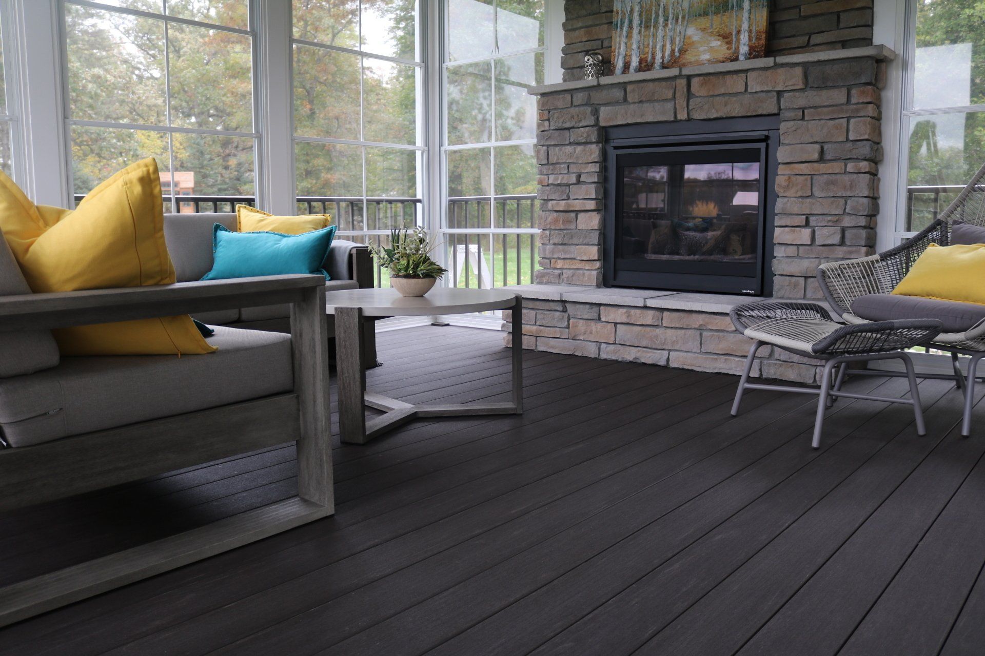 A living room with a fireplace and a screened in porch.