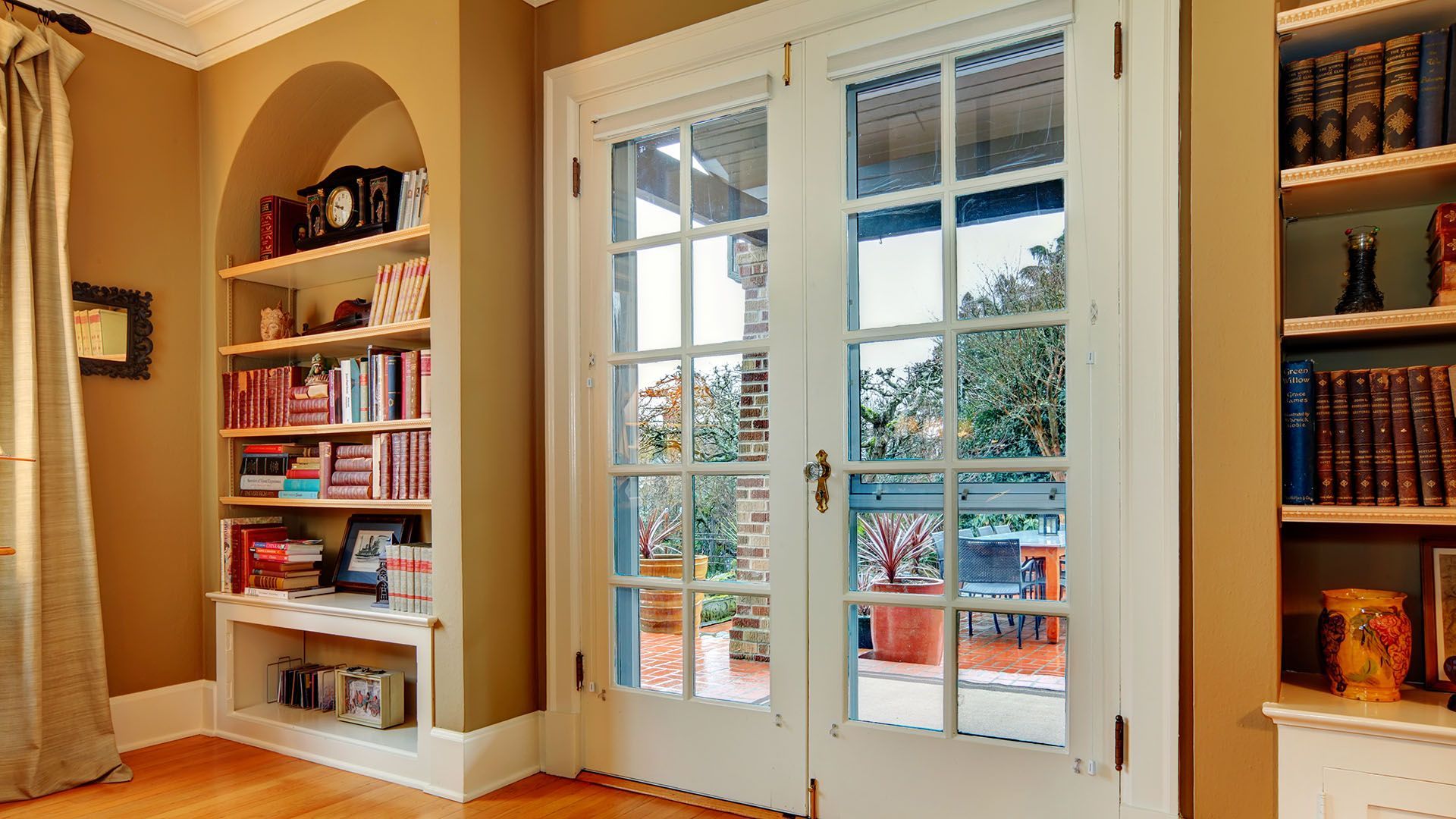 Living room with arched built-in shelf next to buffet exterior door