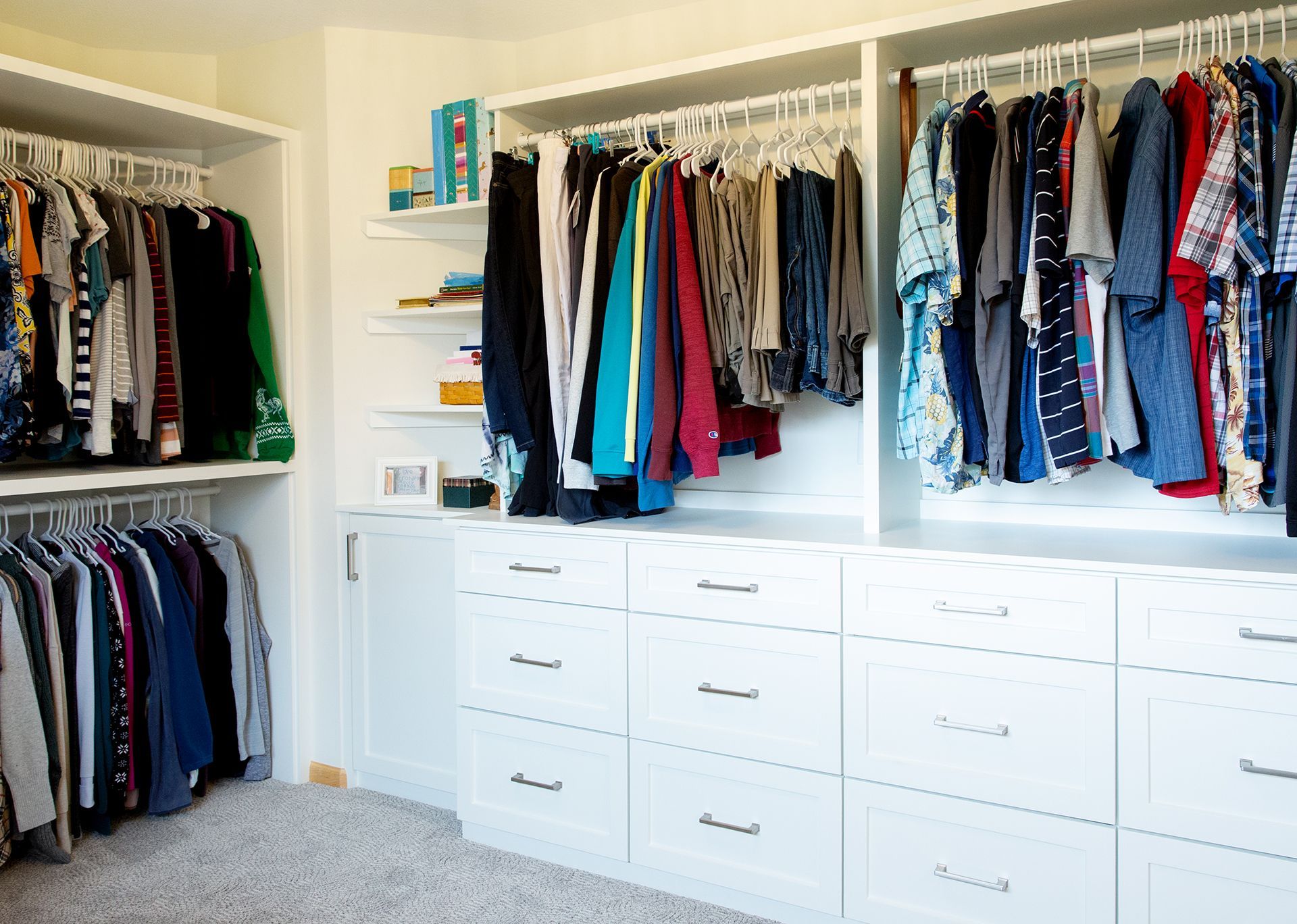 A walk in closet filled with lots of clothes and drawers.