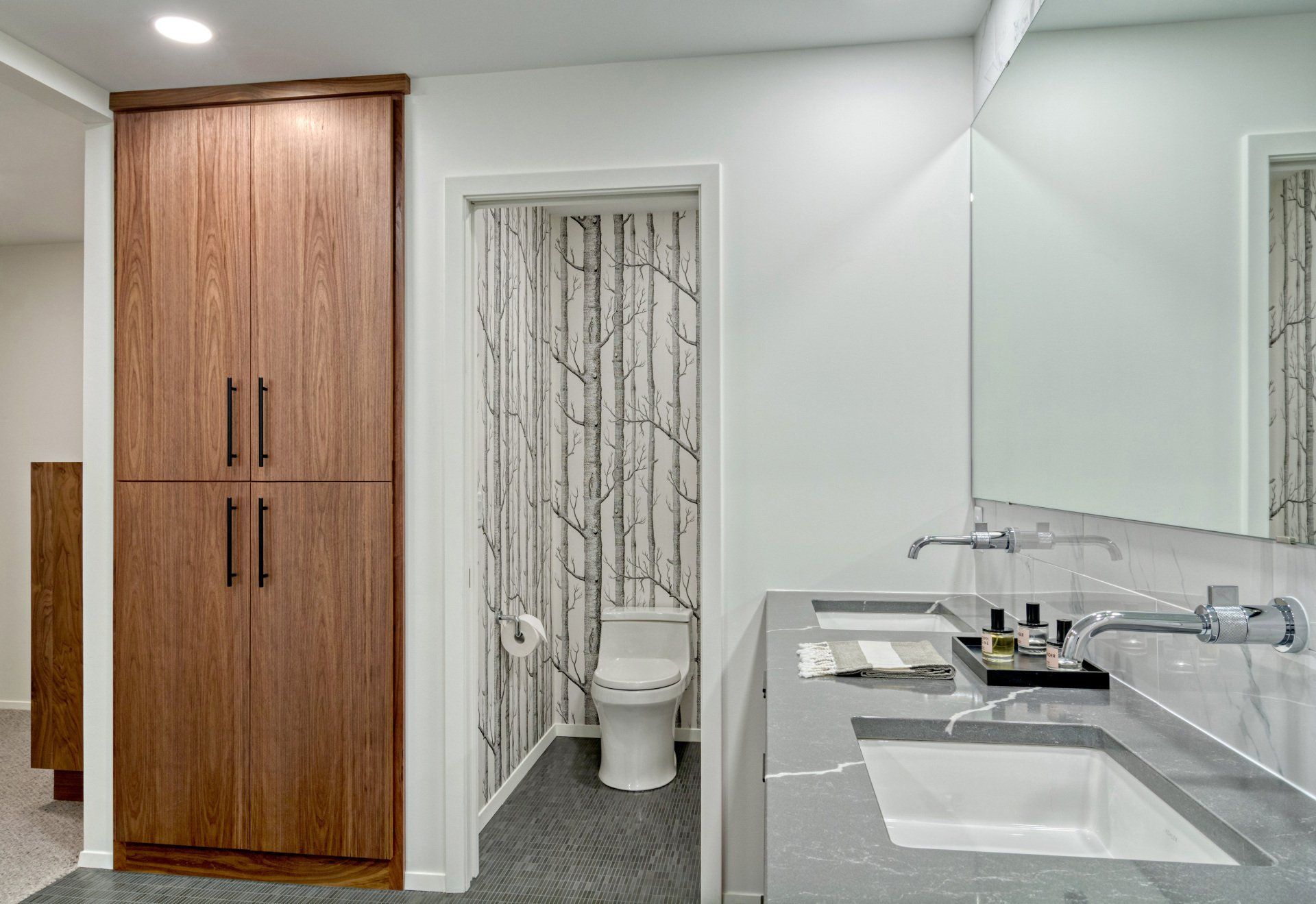 A bathroom with a toilet , sink and mirror.