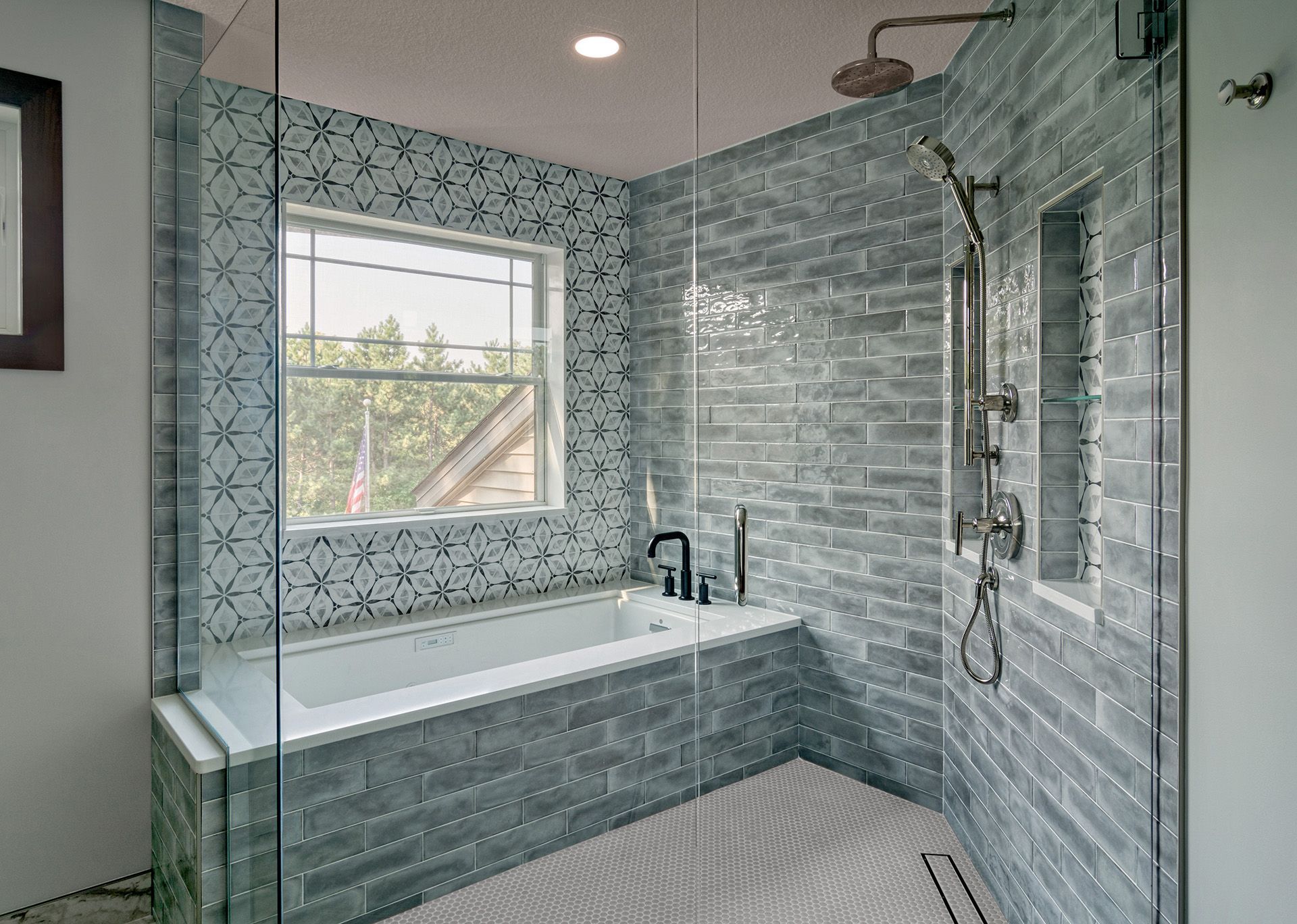 A bathroom with a tub , shower , and window.