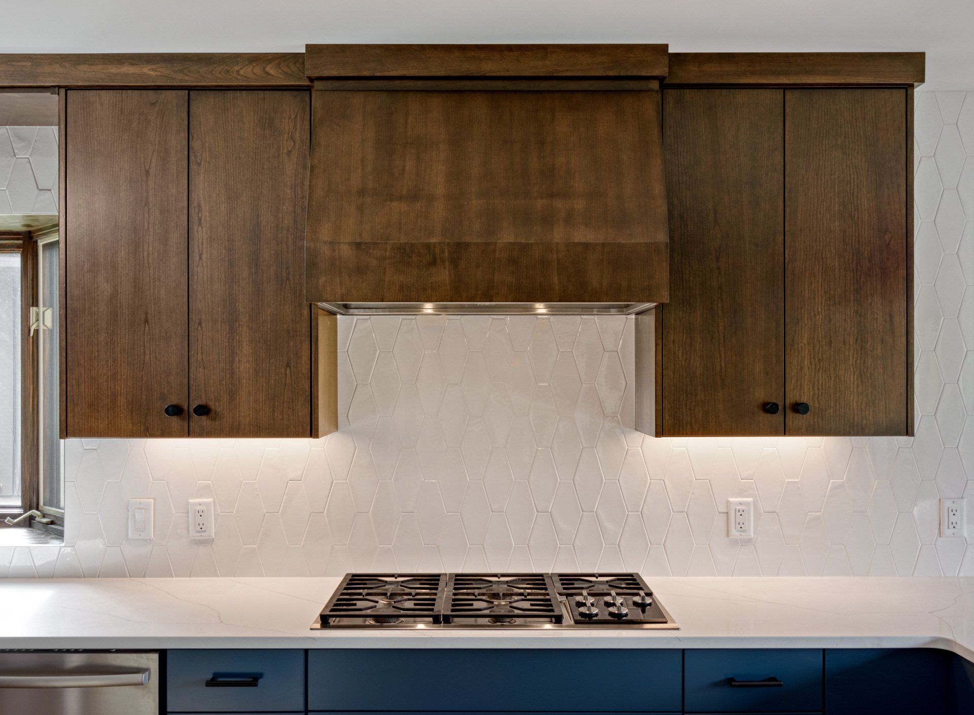 A kitchen with wooden cabinets and a stove top oven.