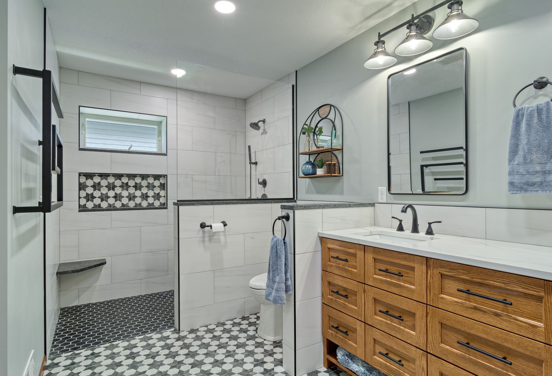 A bathroom with a walk in shower , sink and mirror.