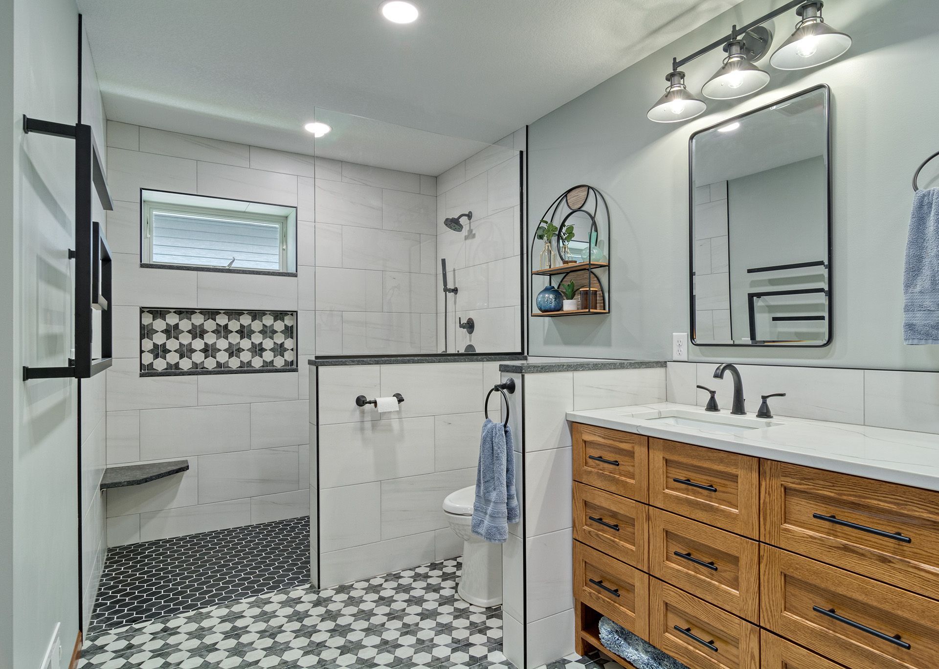 A bathroom with a walk in shower , sink and mirror.