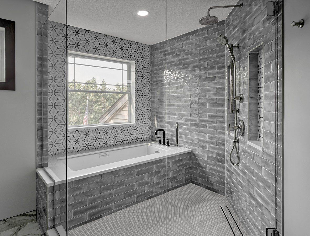 A bathroom with a tub , shower , and window.