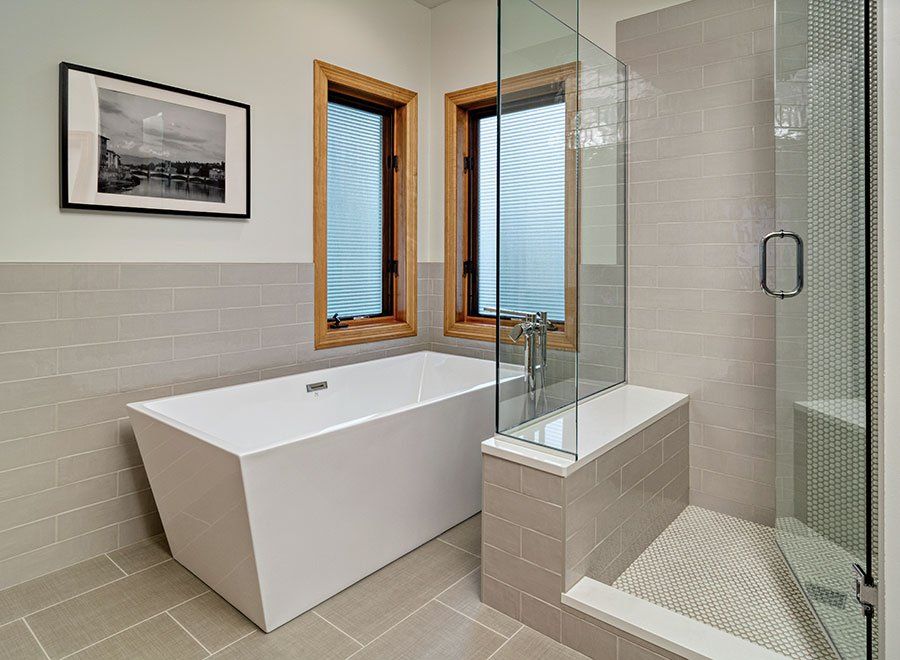 A bathroom with a bathtub and a walk in shower.