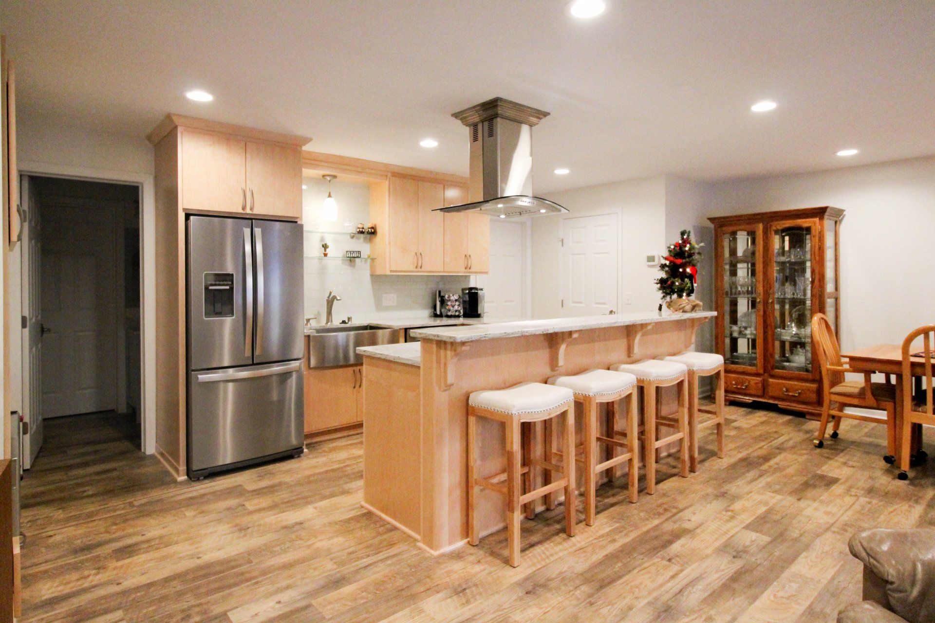 A kitchen with stainless steel appliances and wooden floors.