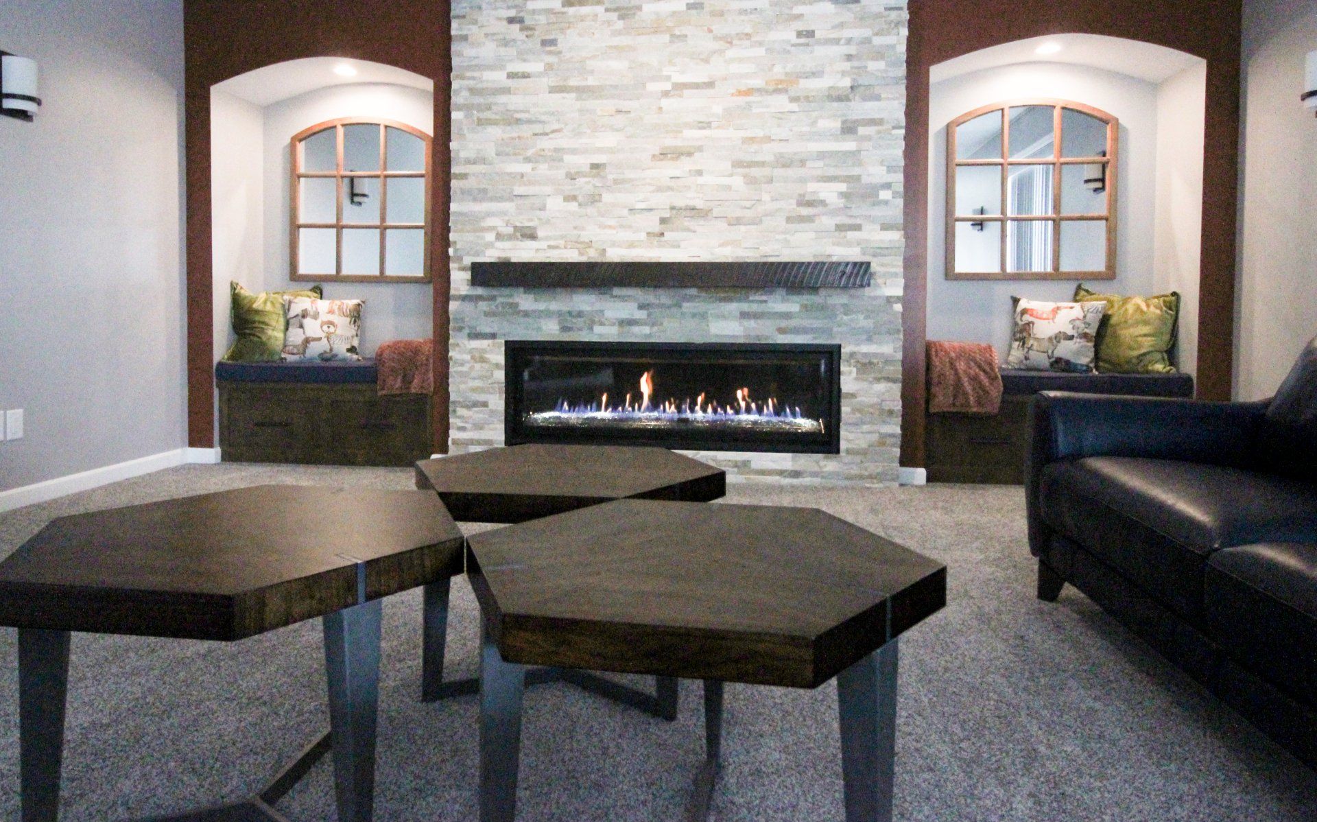 A living room with a fireplace and three coffee tables