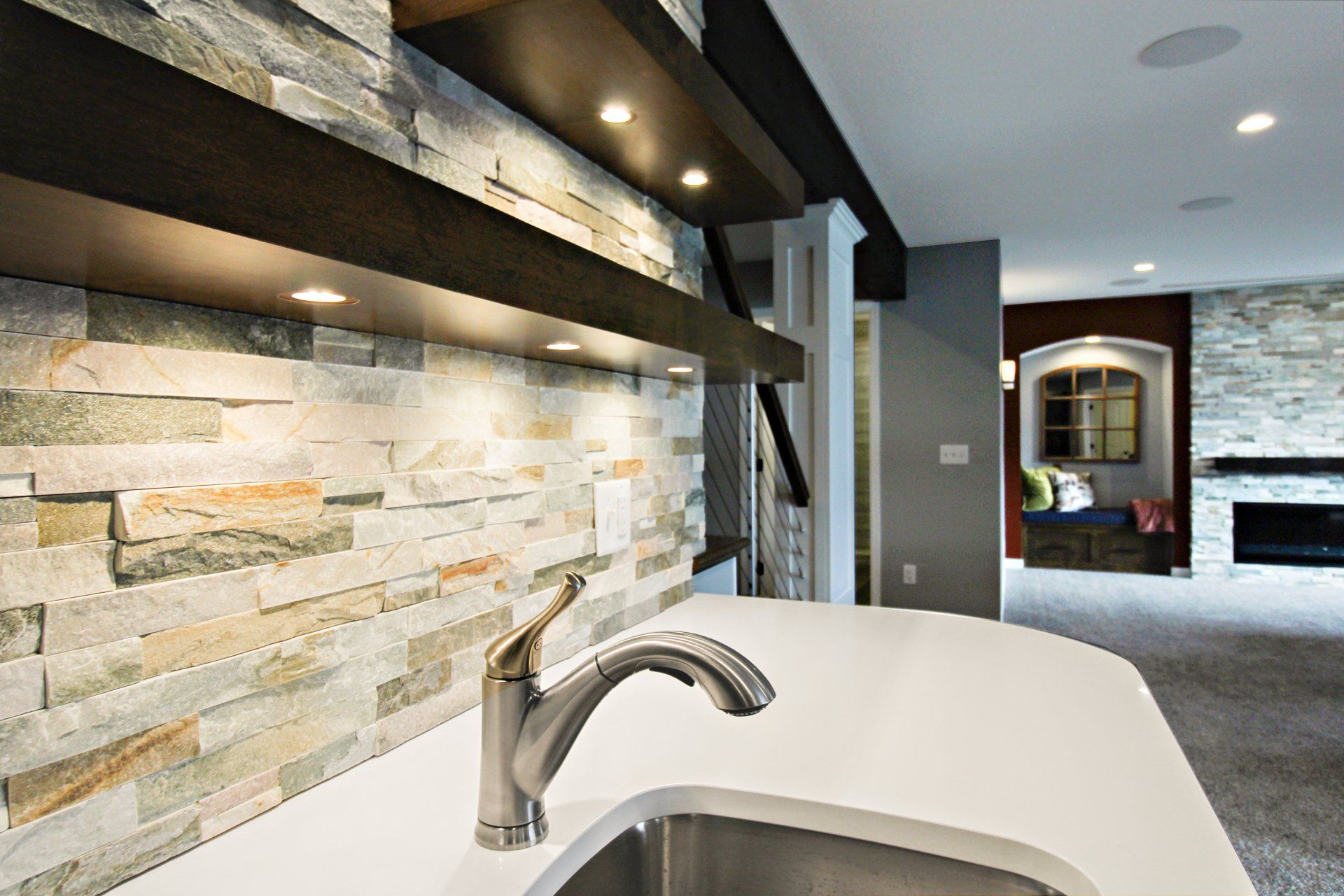 A kitchen with a sink and a stone wall