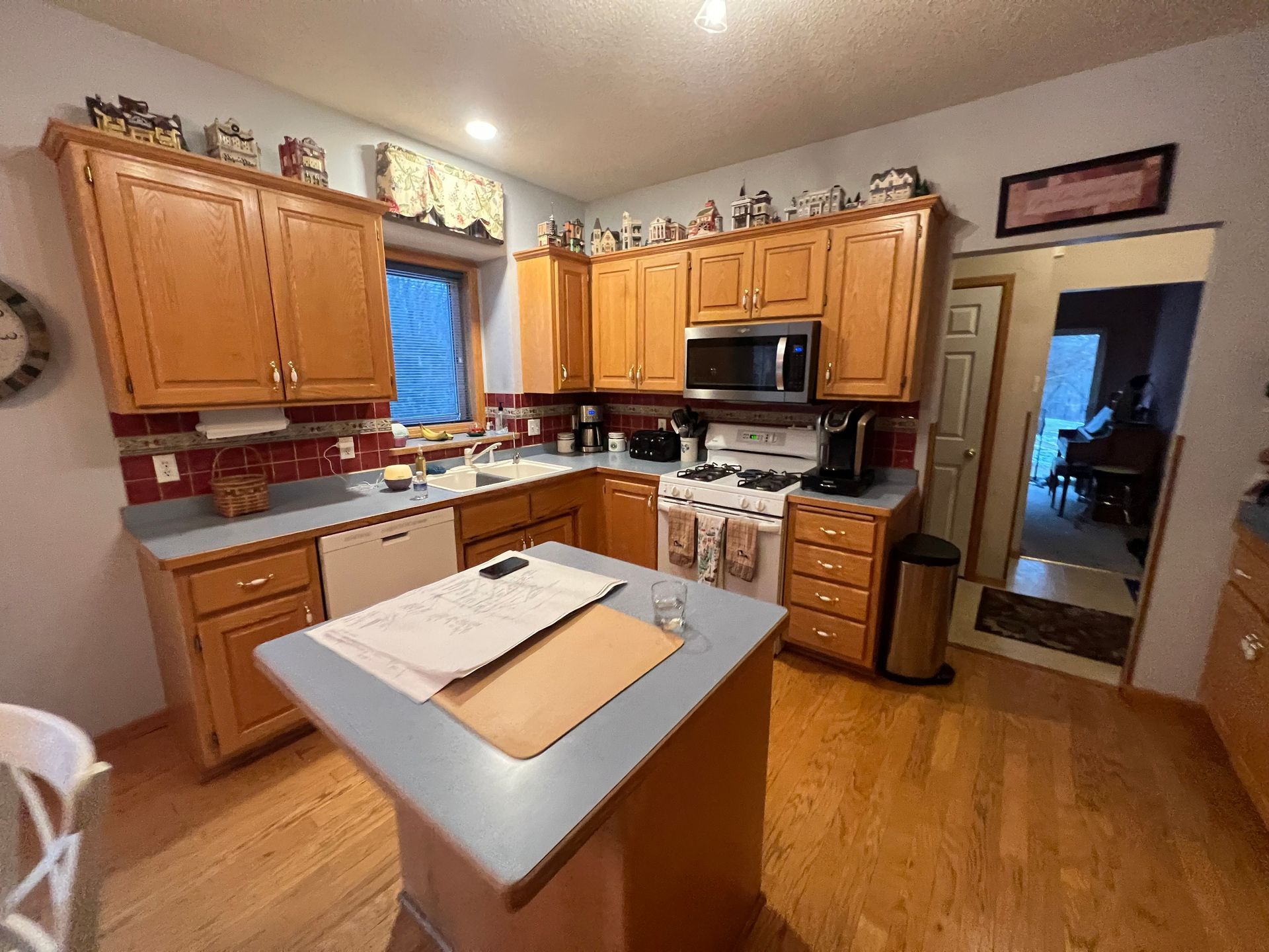 Before photo of oak cabinets and red backsplash