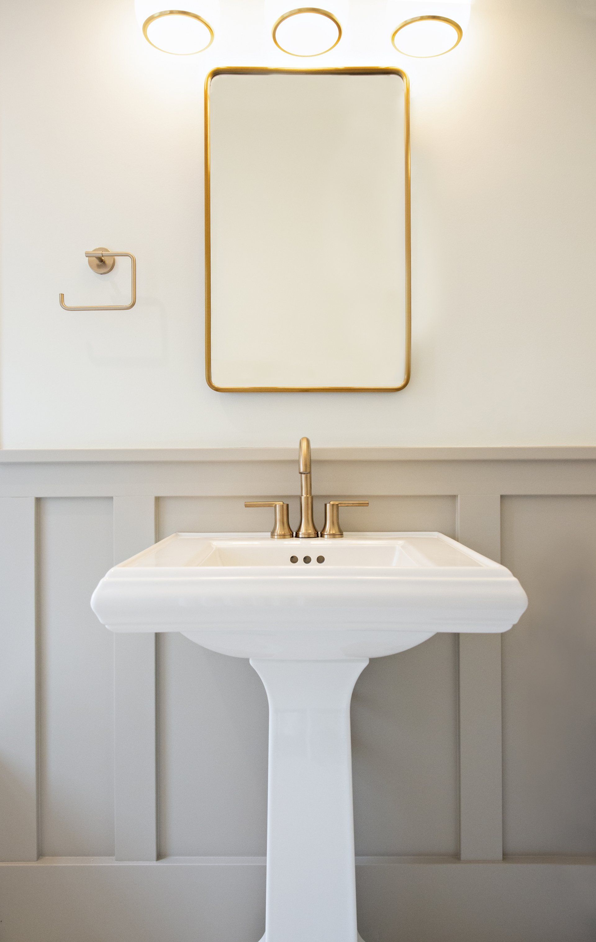 A bathroom with a pedestal sink and a mirror.