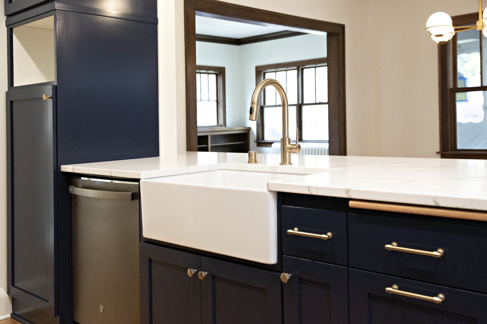 A kitchen with blue cabinets and a white farmhouse sink