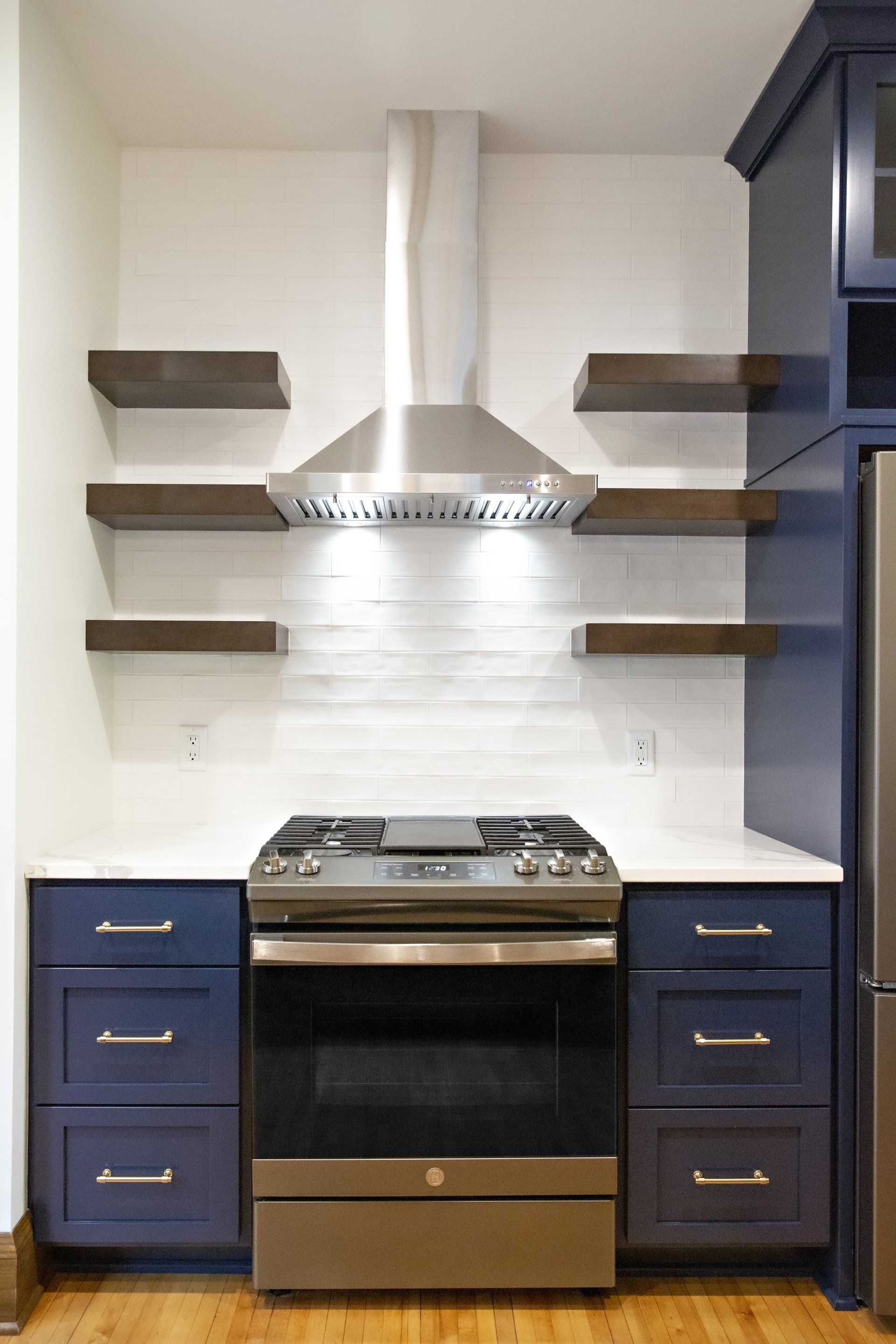 A kitchen with stainless steel appliances and blue cabinets