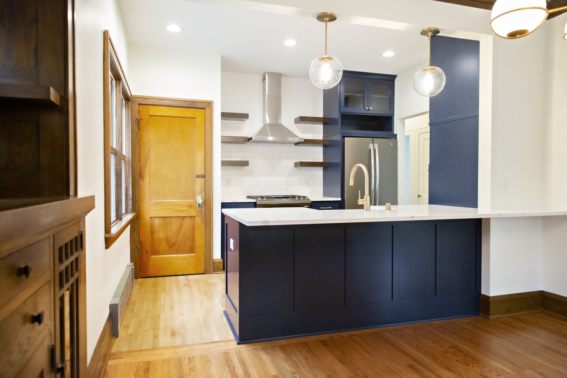 A kitchen with blue cabinets and white counter tops