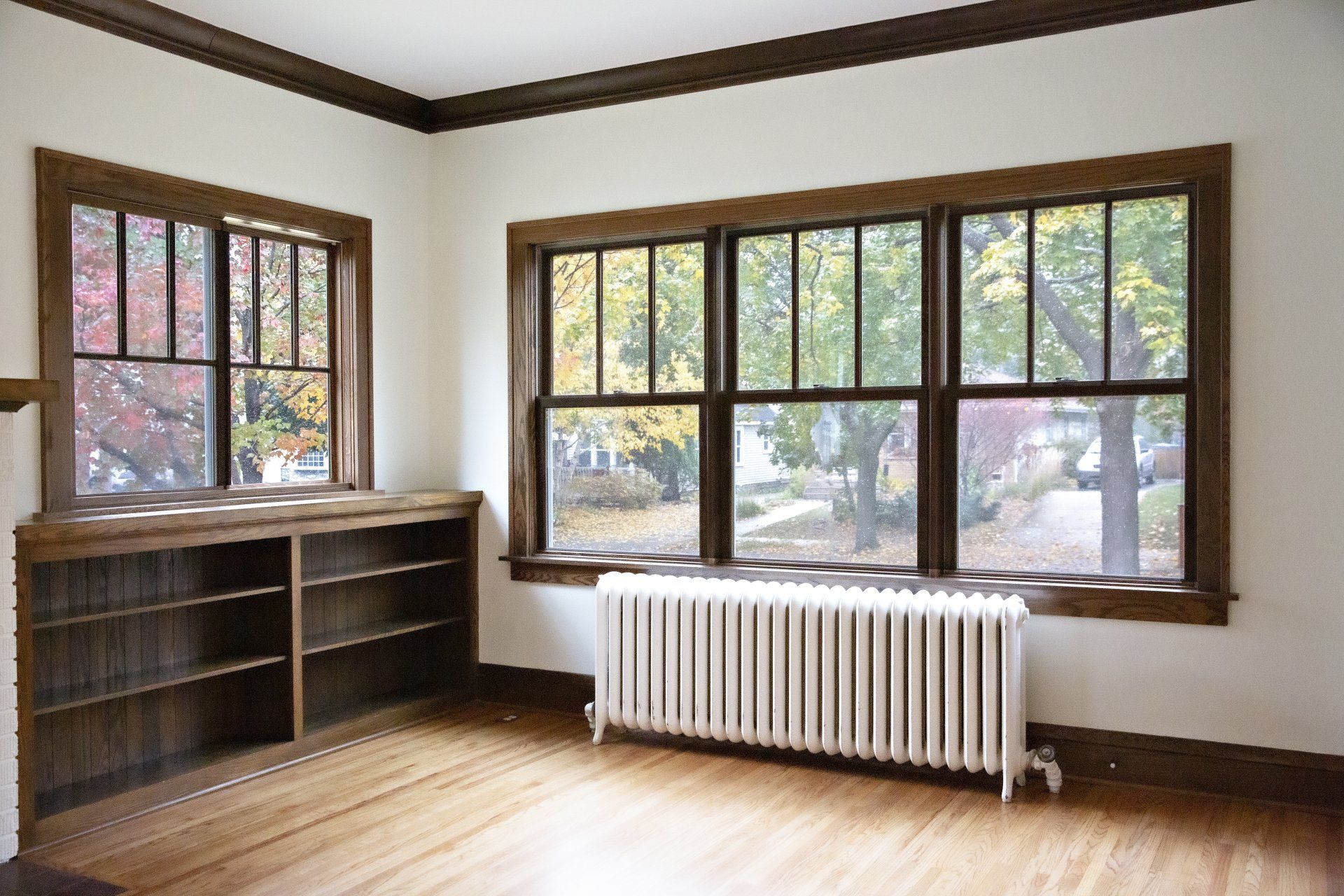 An empty room with two windows and a radiator