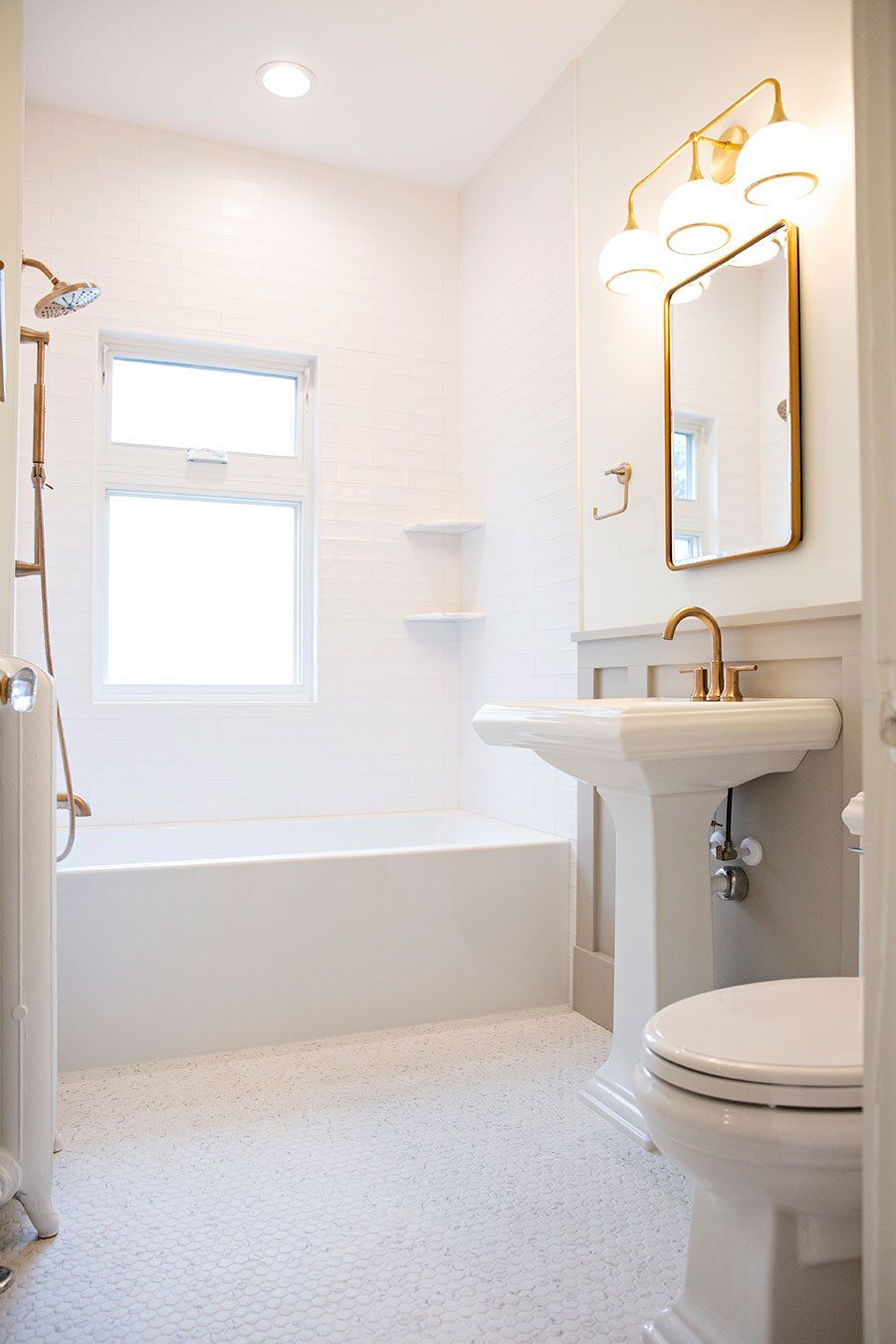 A bathroom with a sink , toilet , tub and mirror.