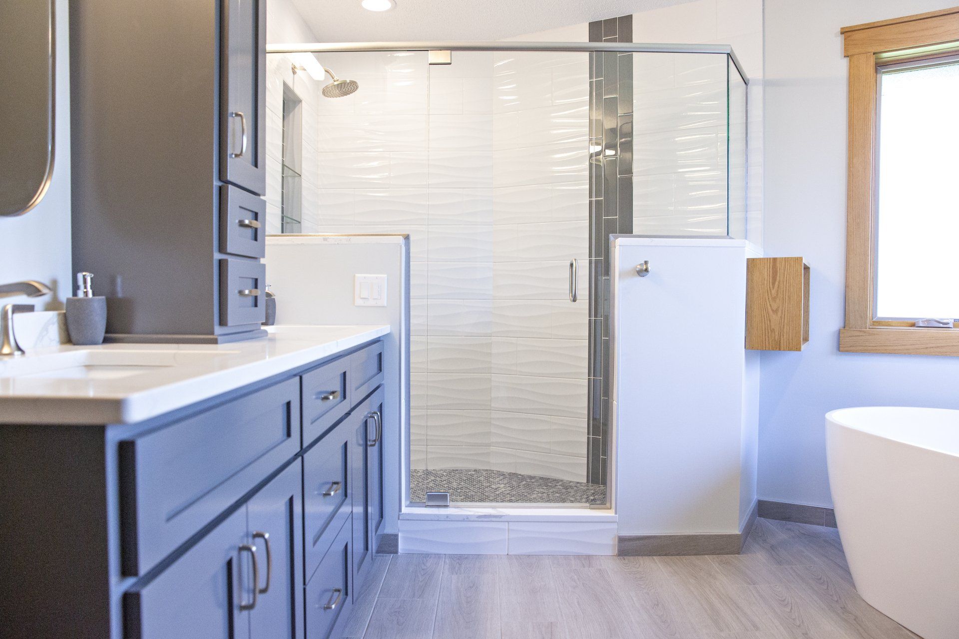 A bathroom with a sink , tub , shower and window.