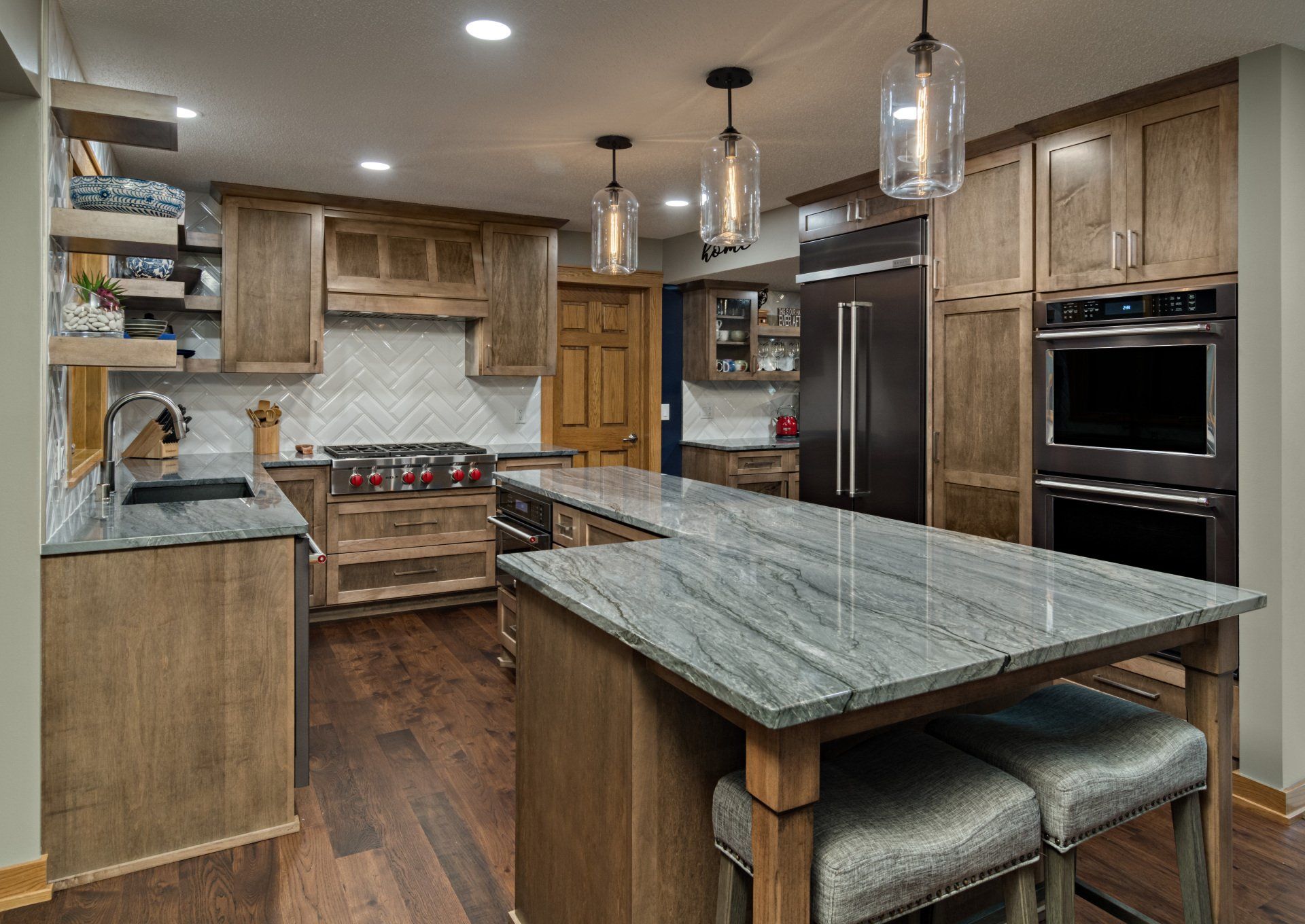 A kitchen with wooden cabinets , granite counter tops , stainless steel appliances and a large island.