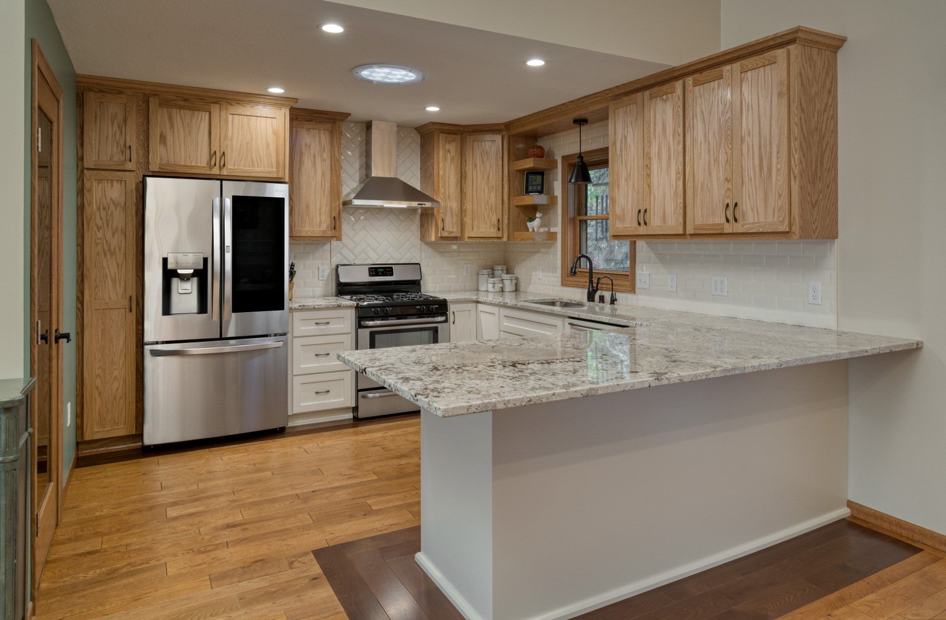 A kitchen with stainless steel appliances , granite counter tops , and wooden cabinets.