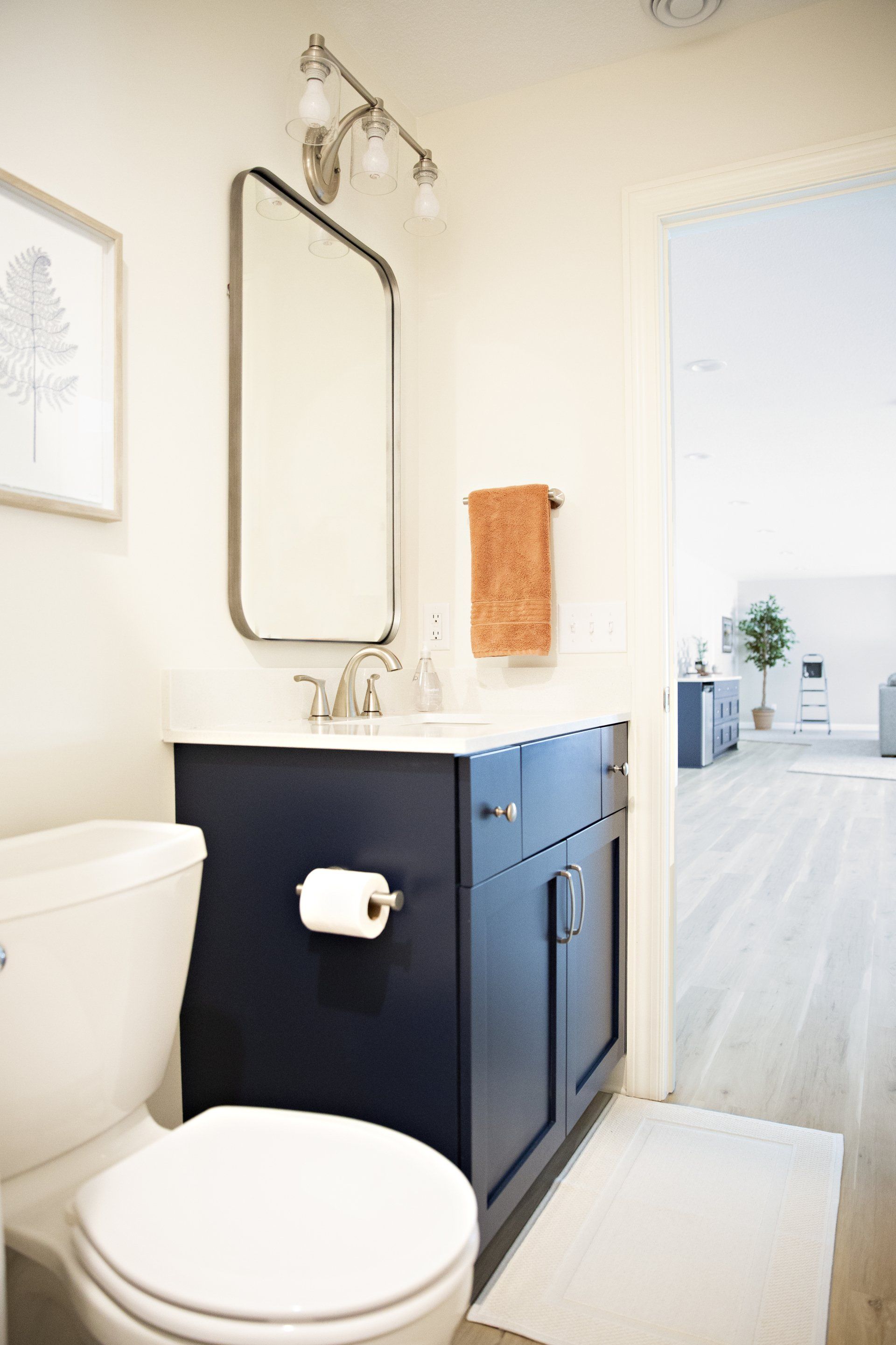 A bathroom with a toilet , sink and mirror.