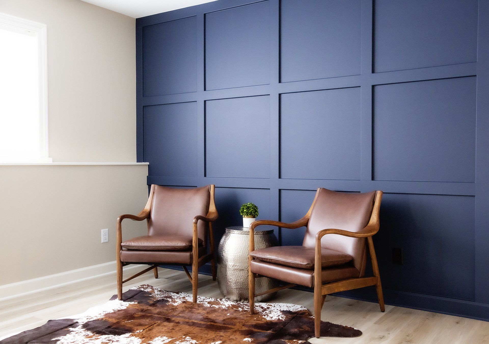 Two chairs are sitting in front of a blue wall.