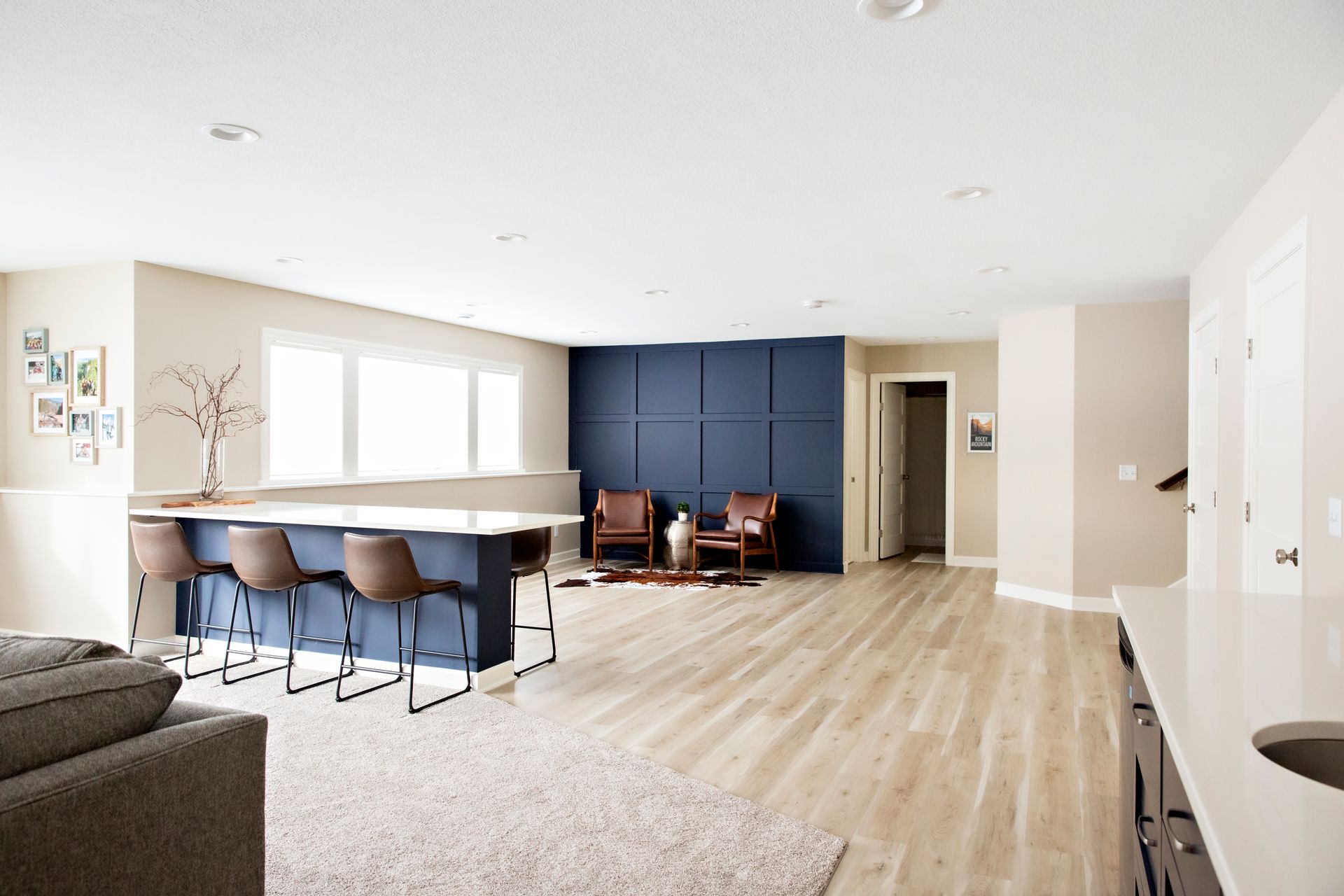 A living room with a couch , chairs , and a bar.