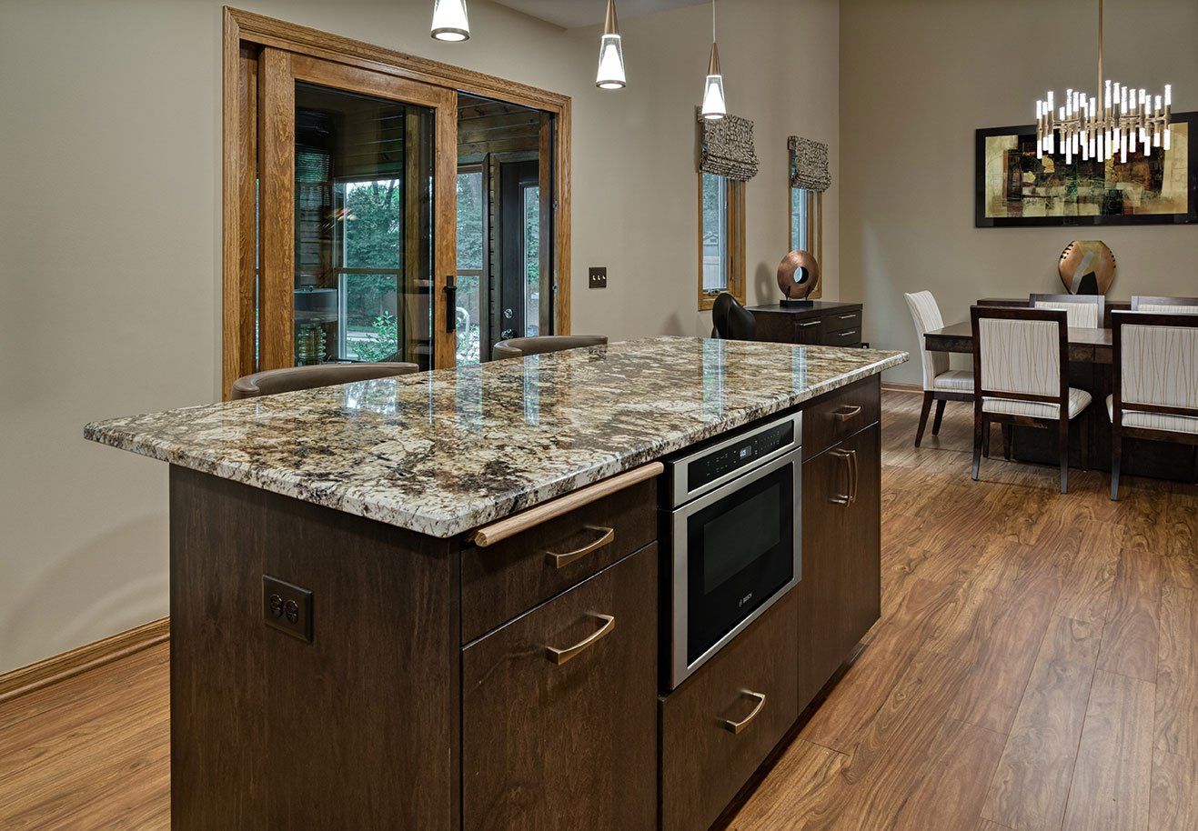 A kitchen with a large island and a dining room in the background.