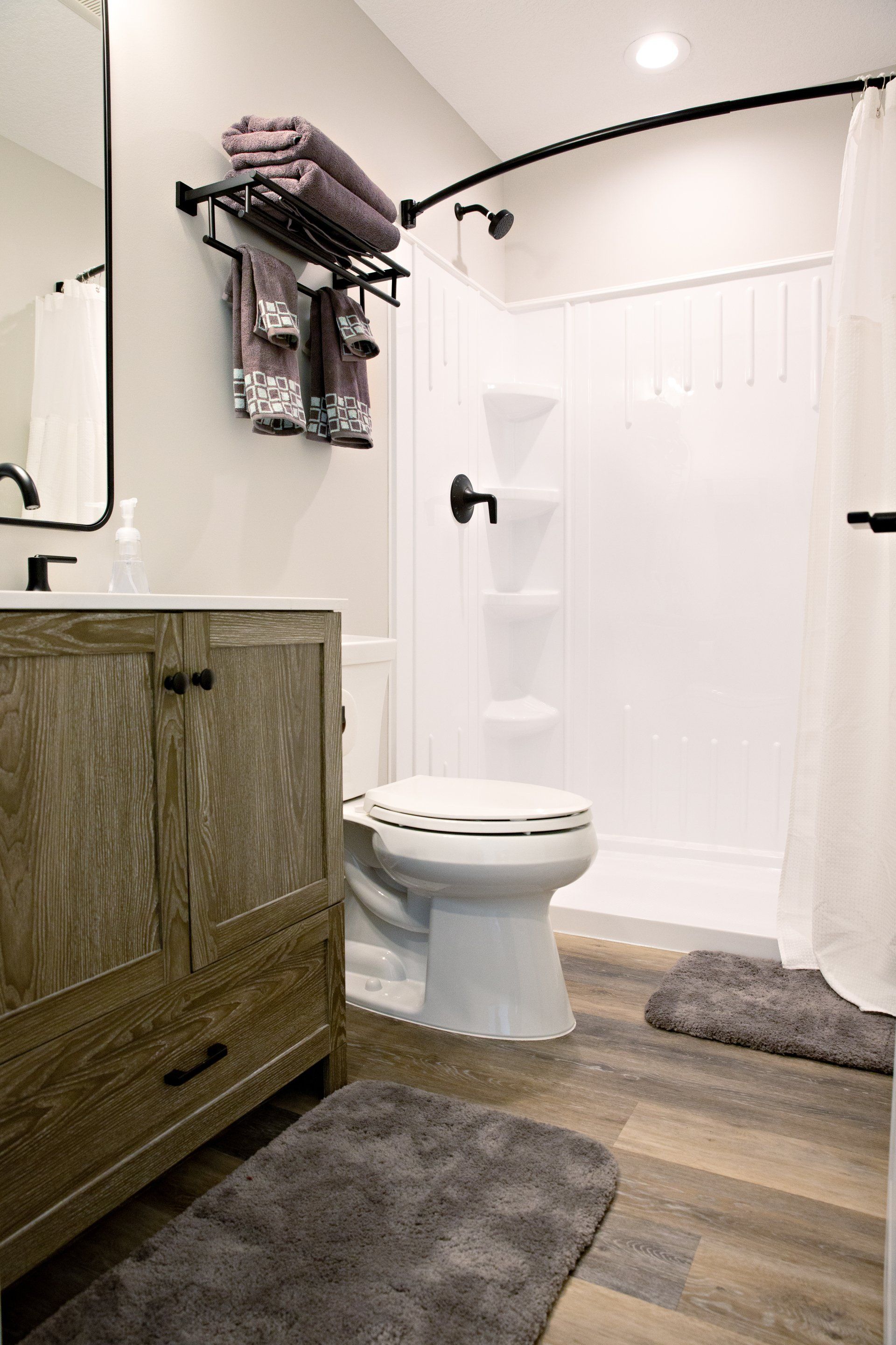 A bathroom with a toilet , sink , and shower.