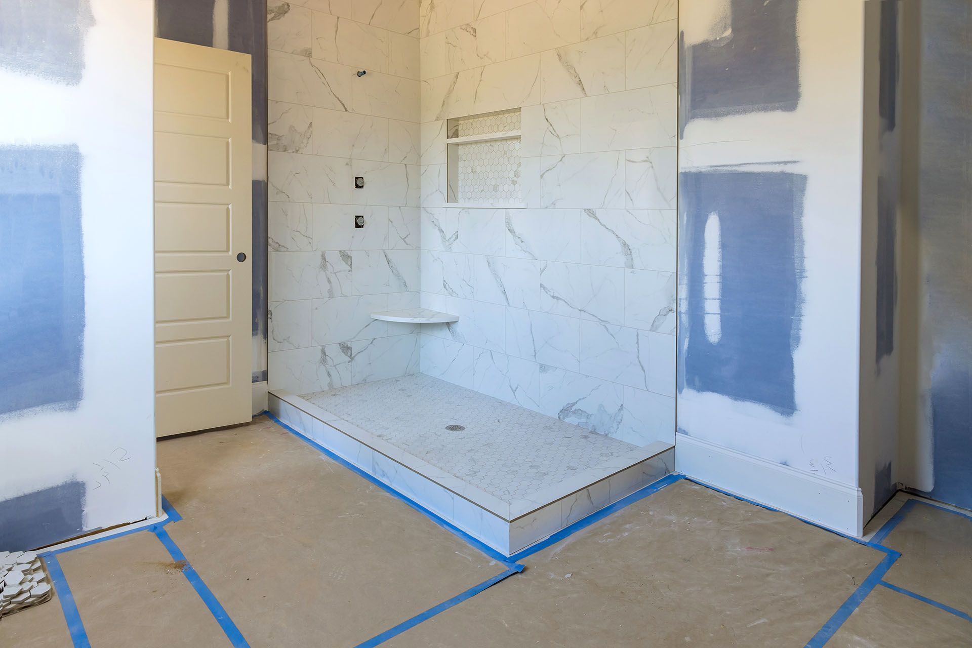 A bathroom under construction with a walk in shower.