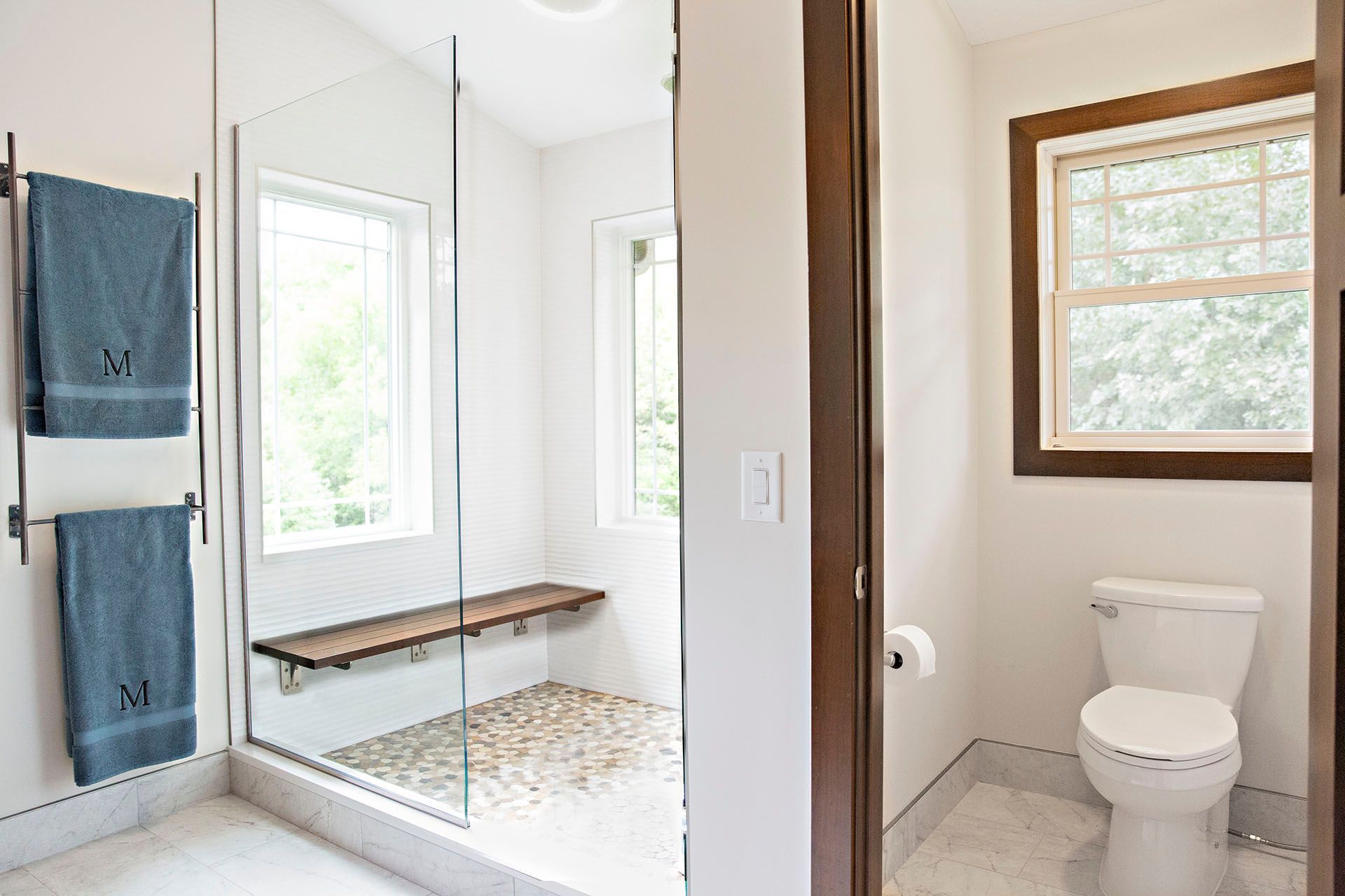 A bathroom with a toilet , shower and window.