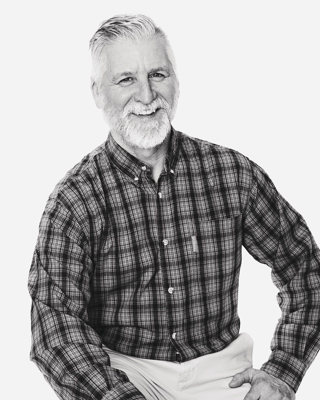 A man with a beard wearing a plaid shirt and apron