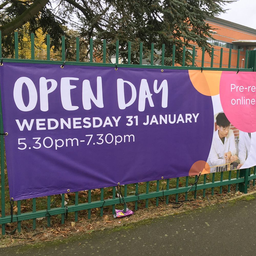 A purple banner on a fence reads 