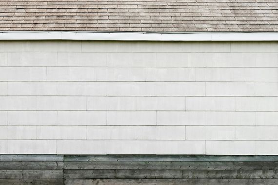 A man is installing a slate roof on a house.