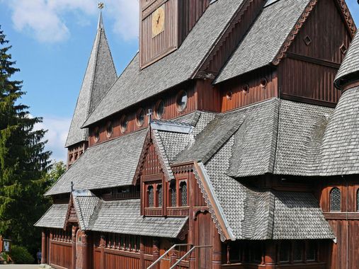 A row of houses with a gray roof and wooden windows