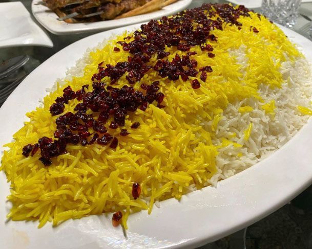 A white plate topped with rice and cranberries on a table.