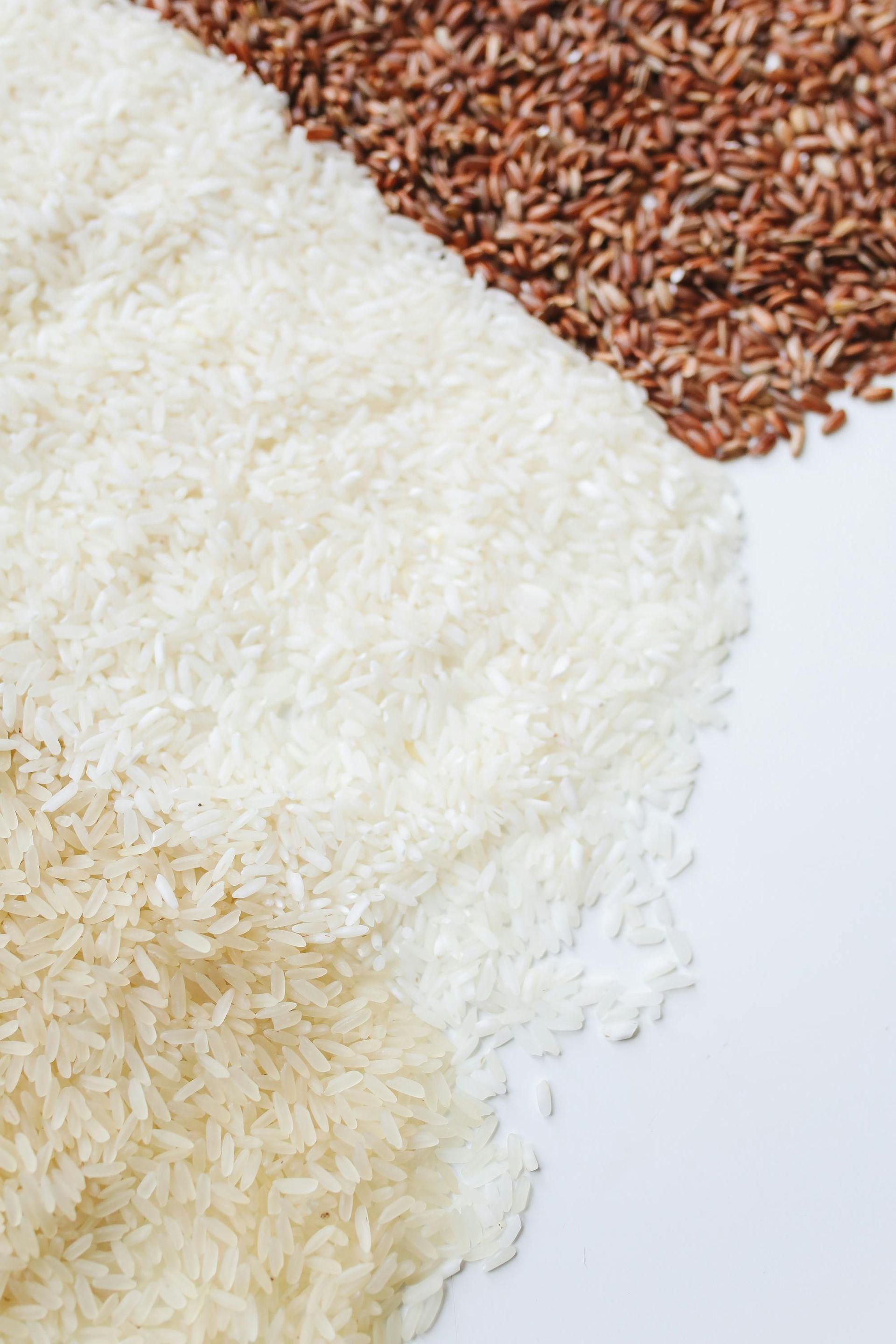 A pile of white and brown rice on a white surface.