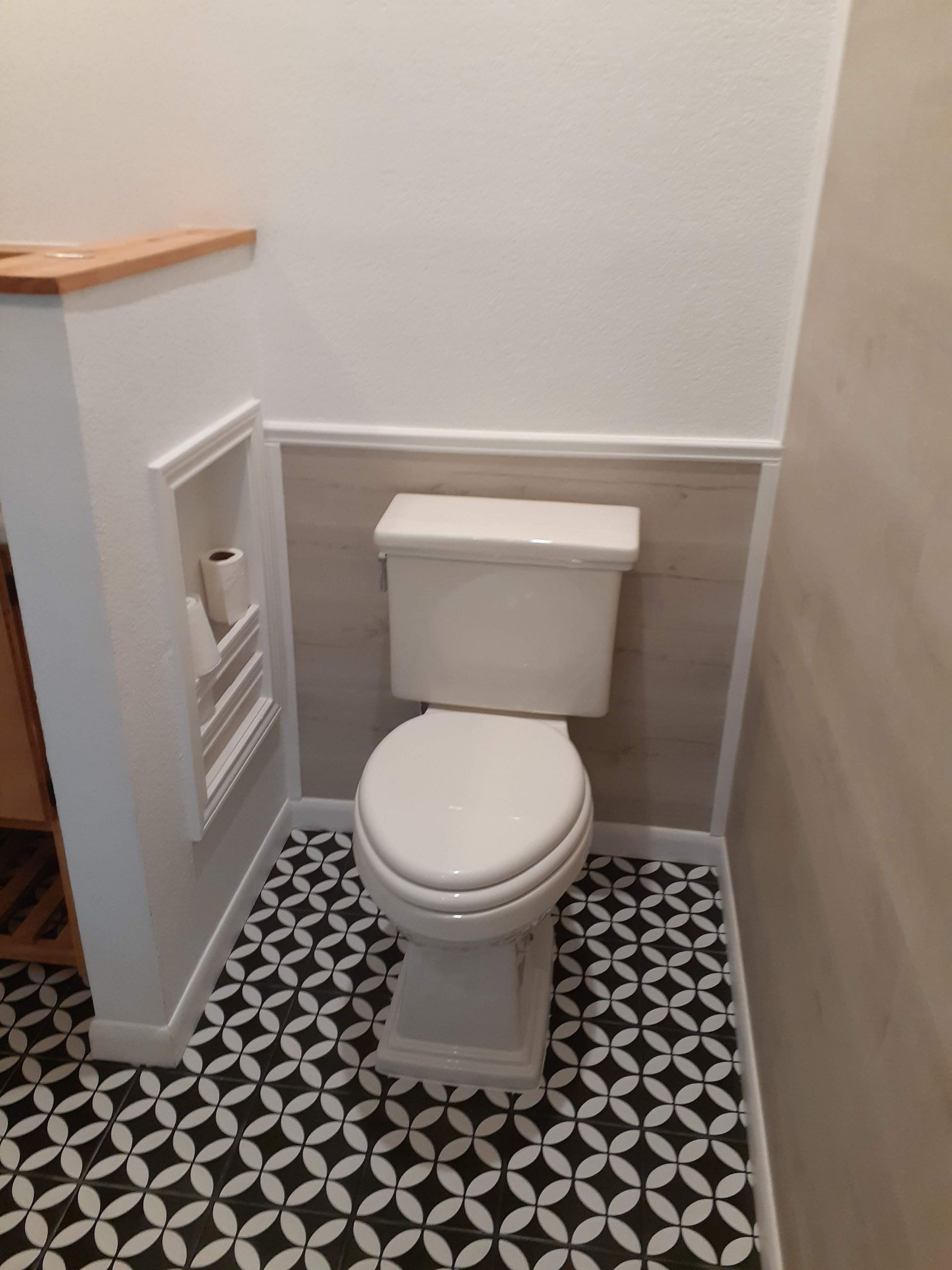 A toilet in a bathroom with a black and white tile floor.